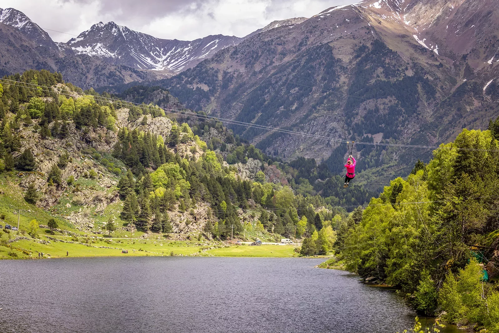 Person zip-lining across a lake
