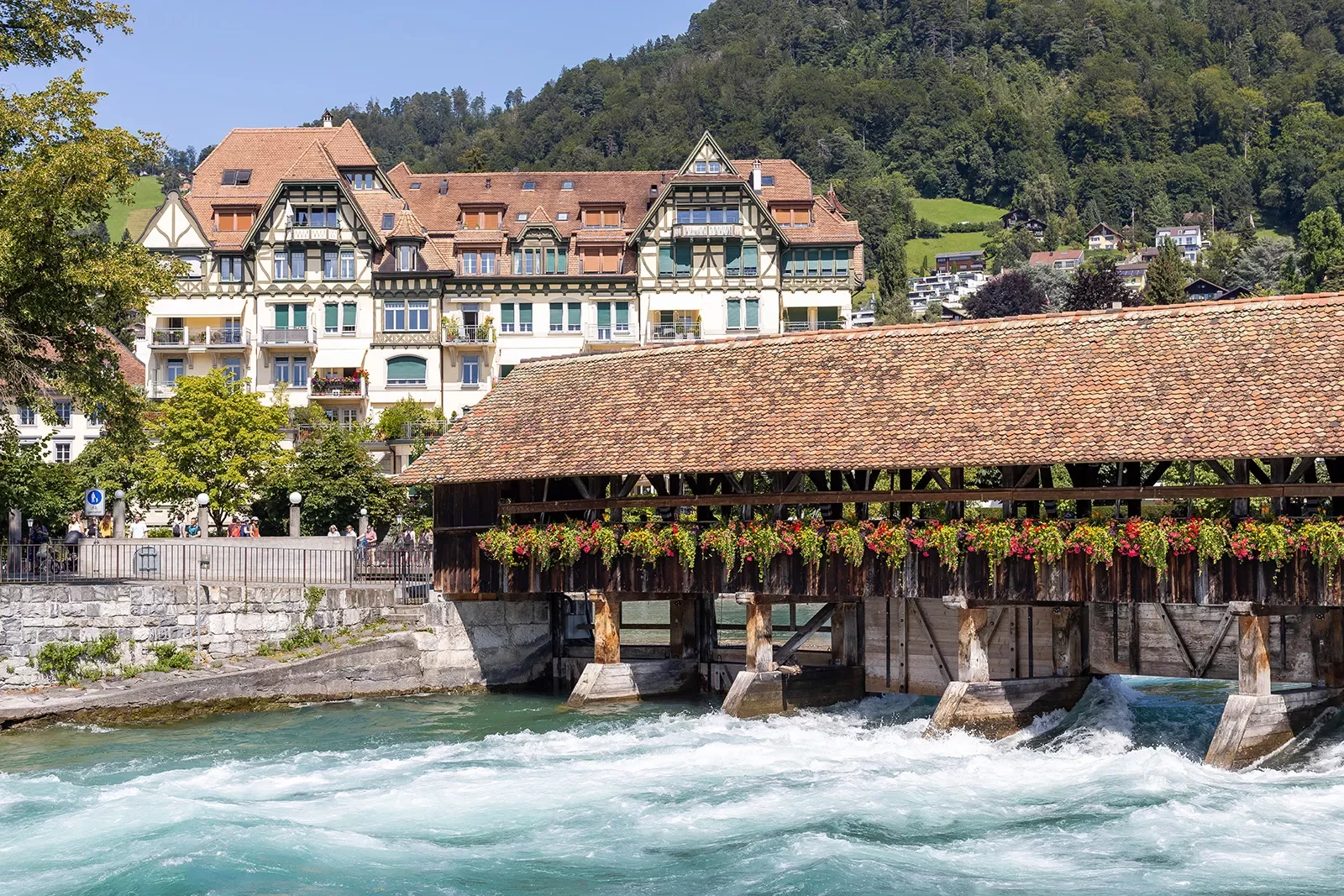 Bridge over the Aare River in Thun, Swiz. Large German style house in background.