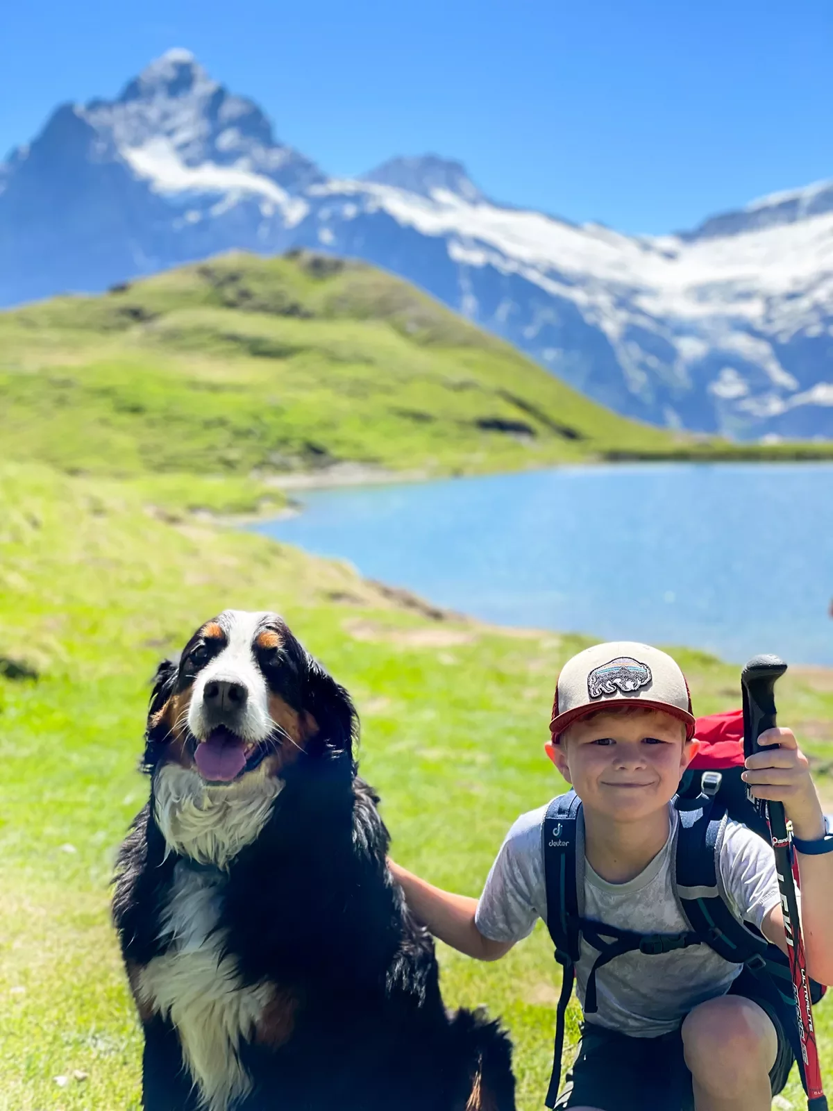 Young guest with dog, lake, mountains in background.