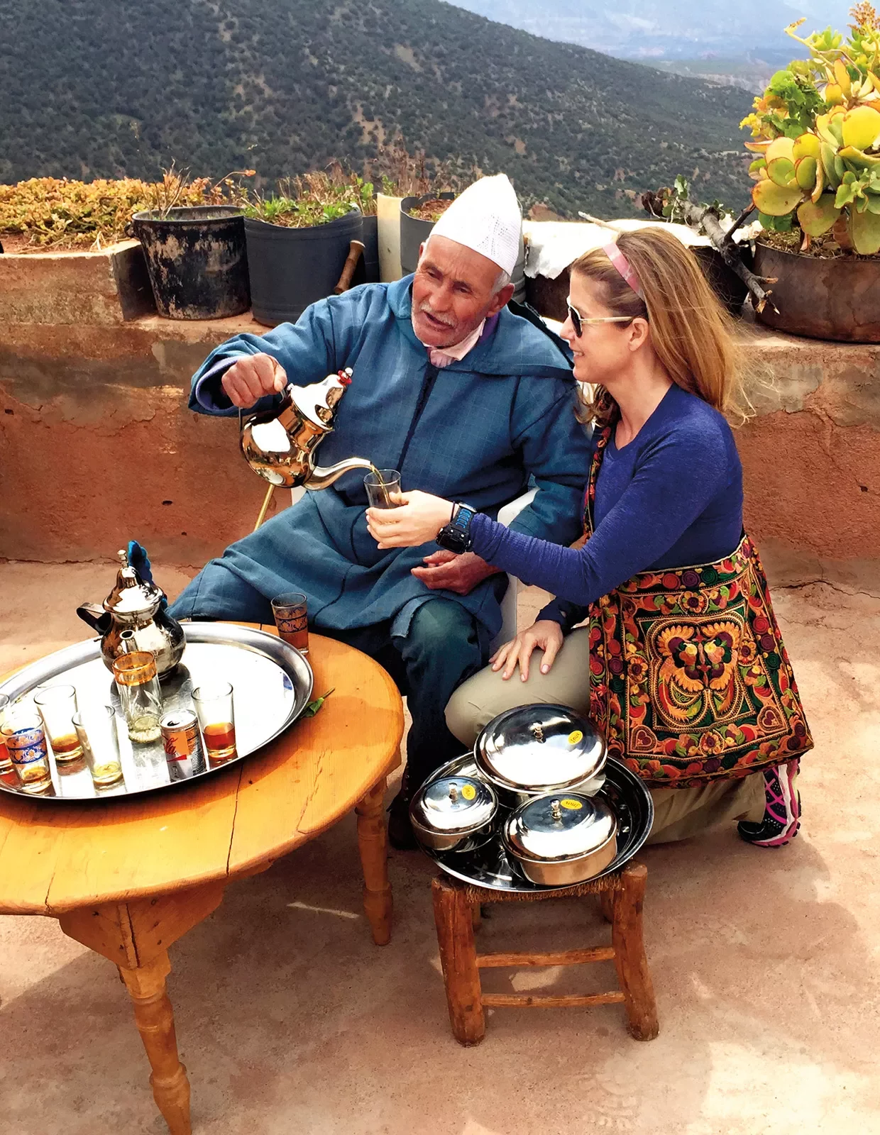 Guest with local, pouring tea.