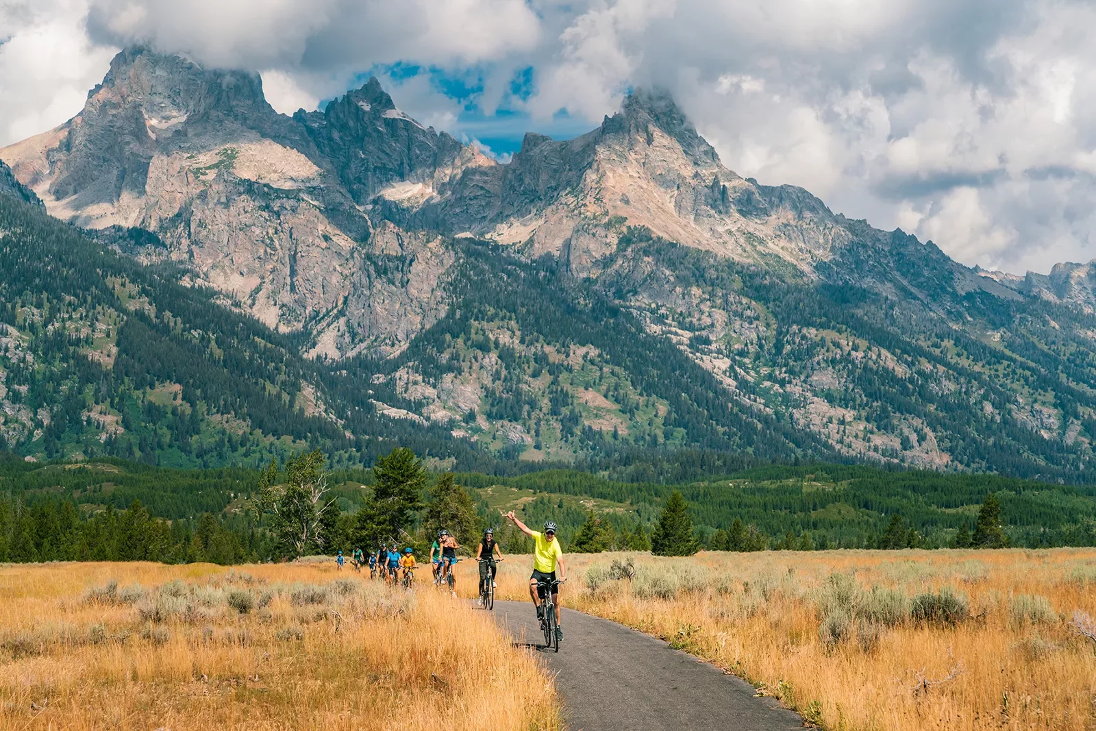 Backroads guests riding through golden fields and rocky mountains