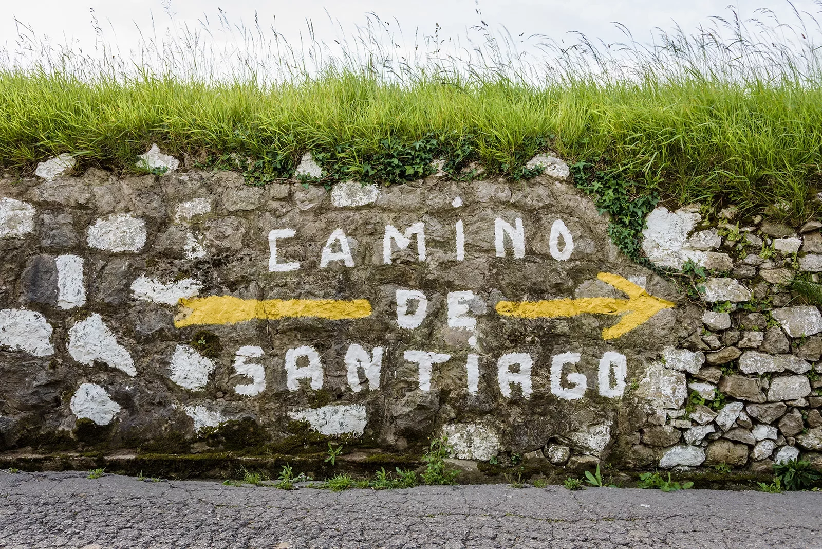 Shot of stone wall with &quot;Camino de Santiago&quot; painted on it.