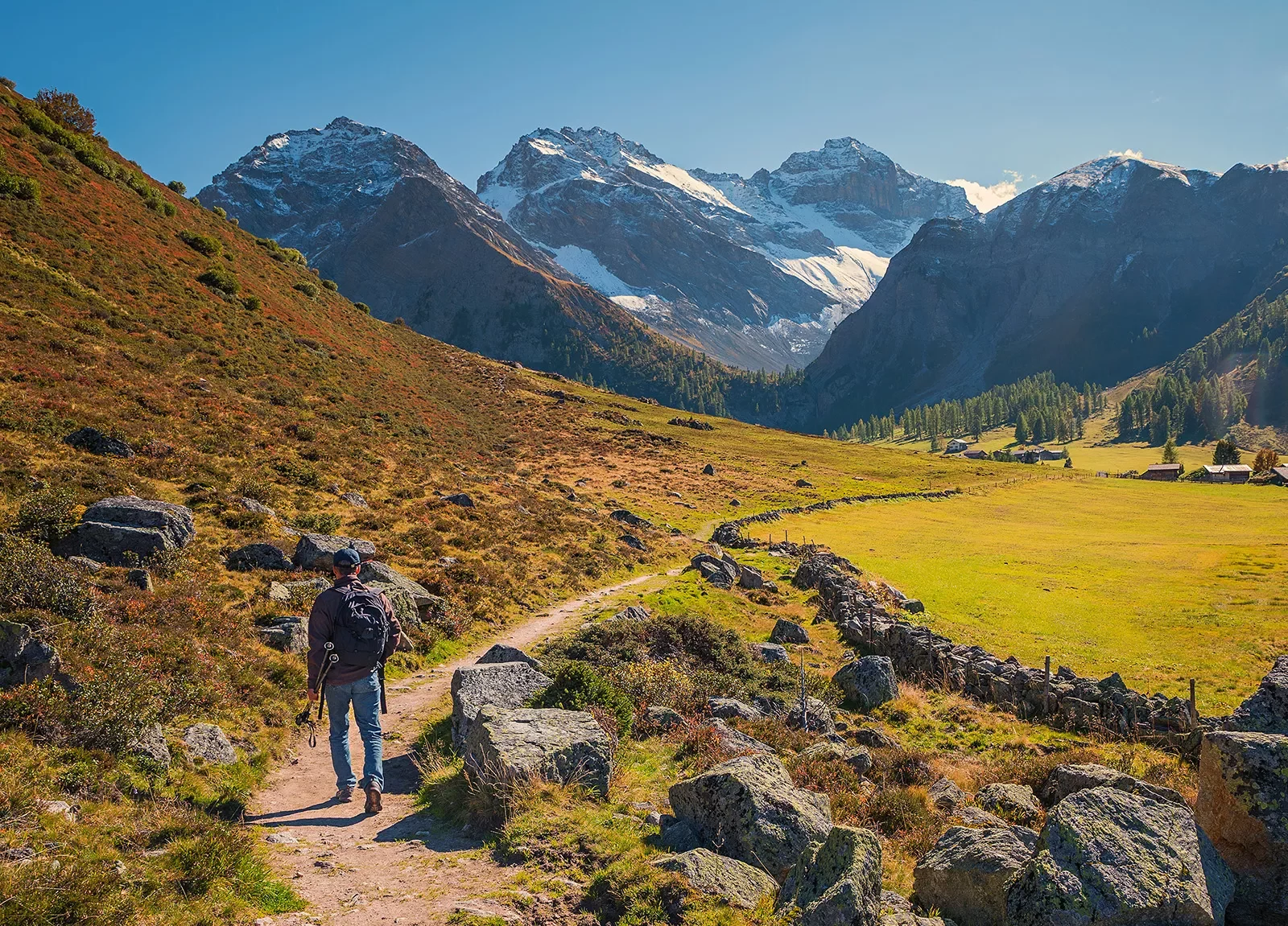 Hiker walking along trail in Swiss Alps.