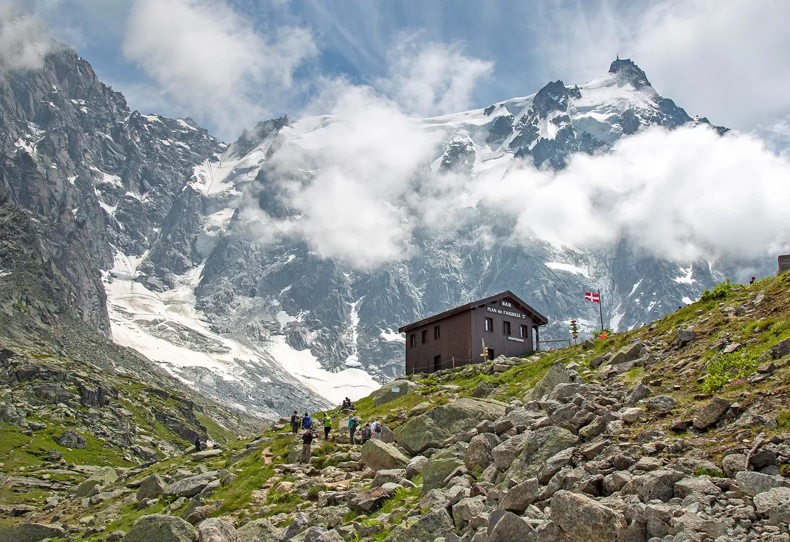 Shot of guests hiking towards the Bar du Plan de l'Aiguille, ring of mountains around them.