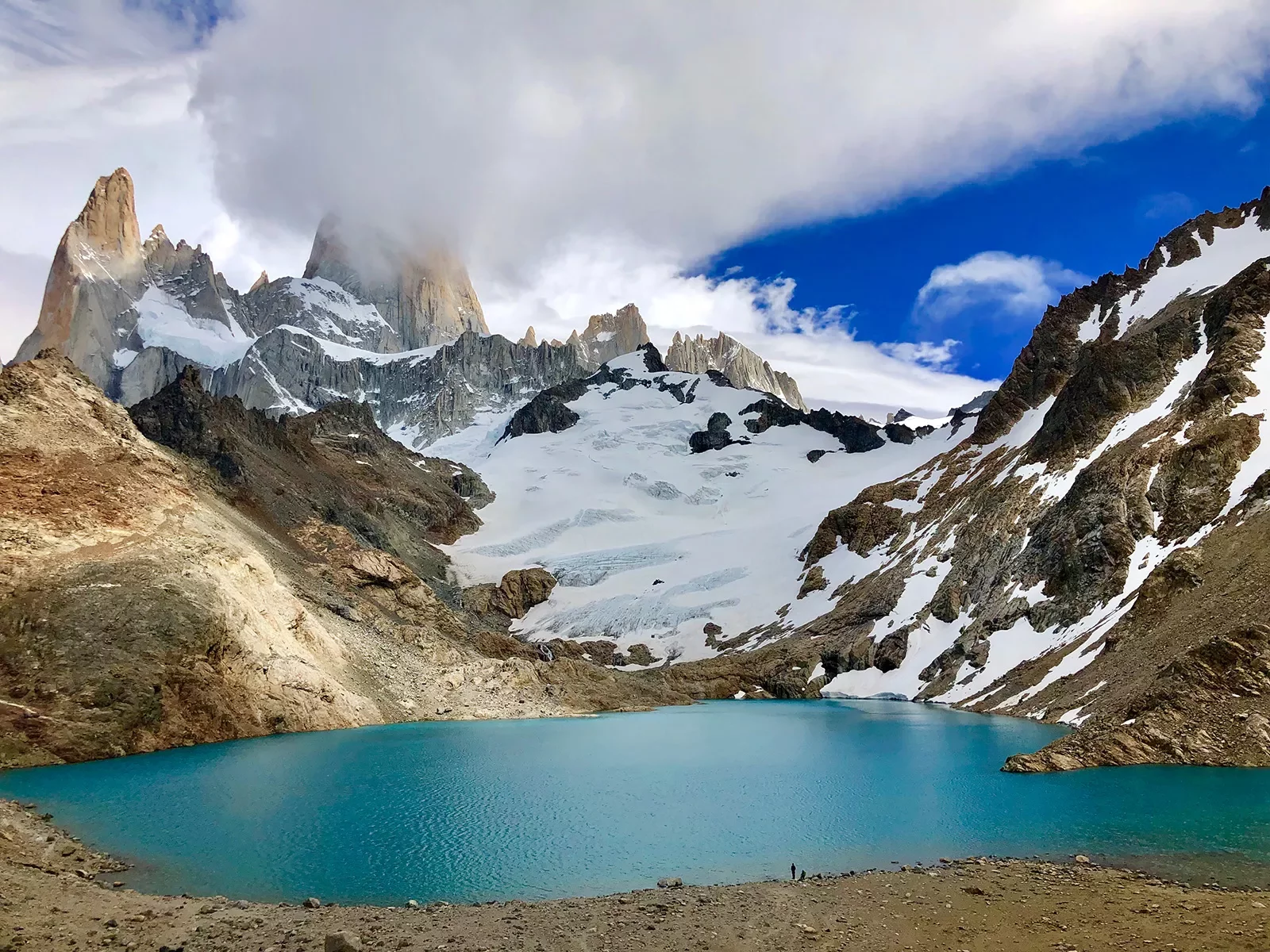 Shot of blue lake, snowy mountain, clouds.