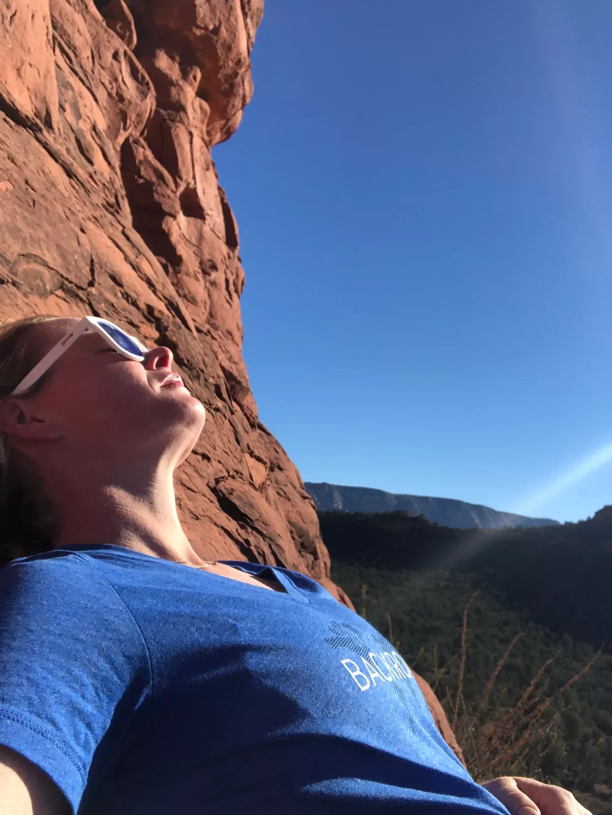Woman resting on a hike, sunbathing.