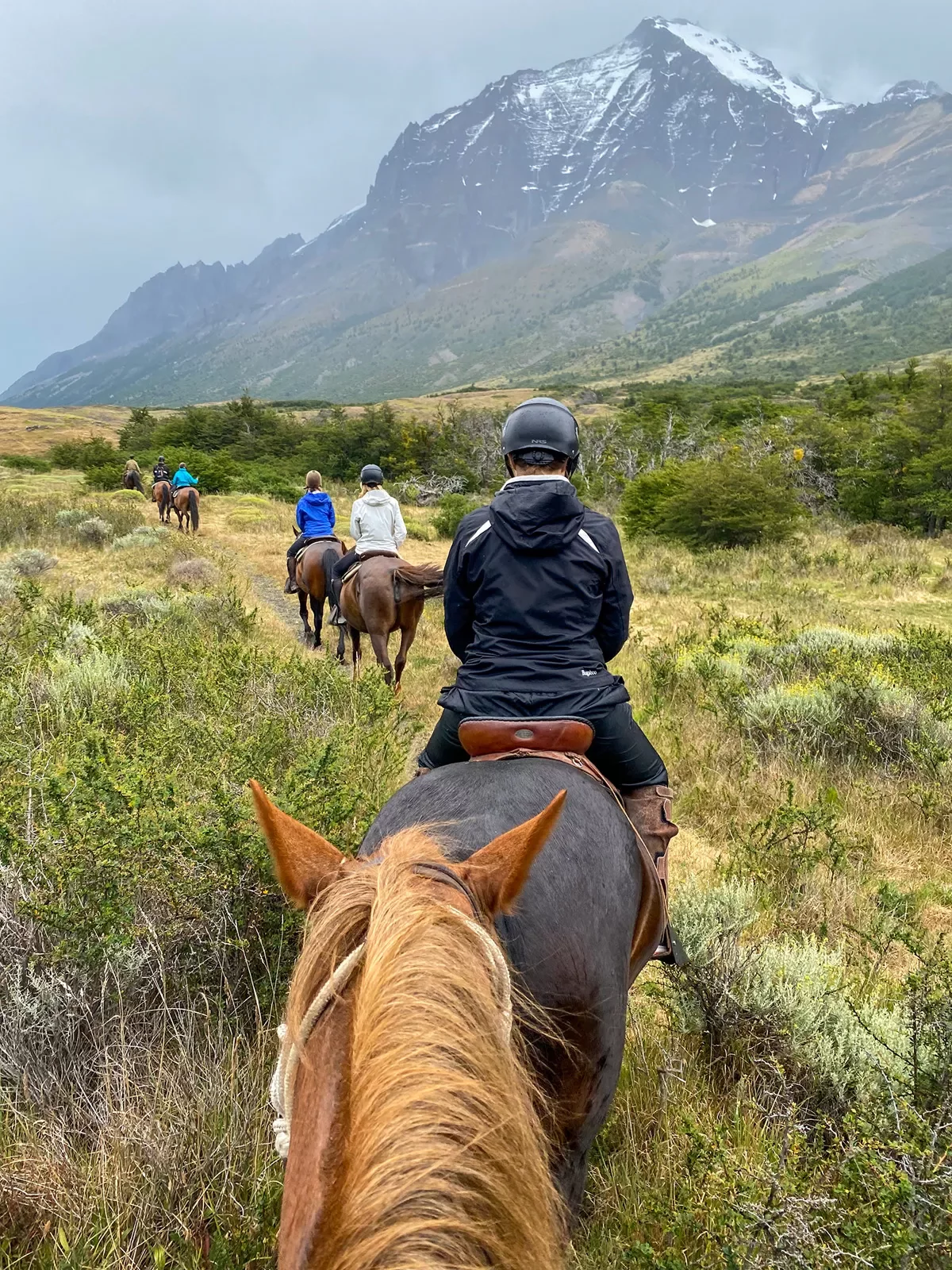 Point of view shot of guests on horseback, heading towards ring of mountains.