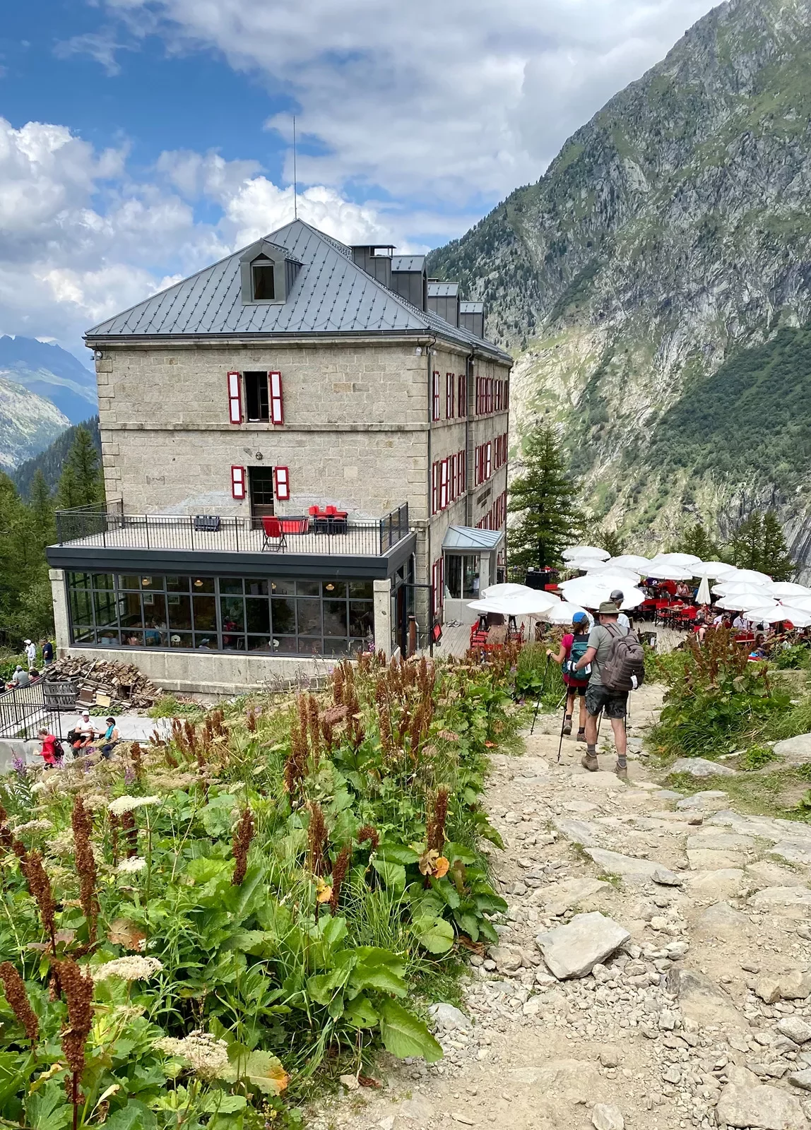 Guests walking towards clifftop restaurant/café. Rocky hillside in background.