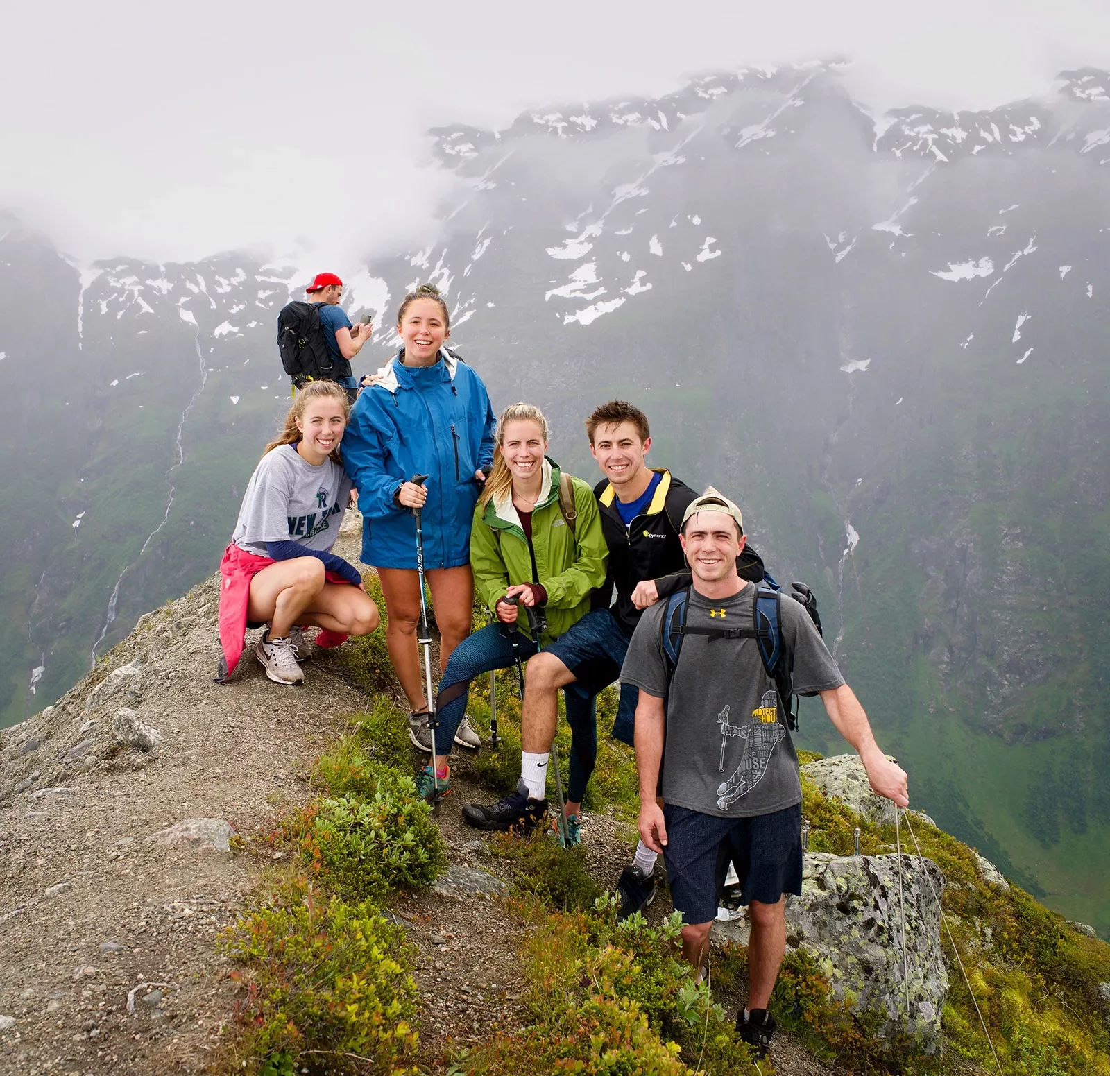 Group of hikers resting at the summit of a foggy mountain in Norway