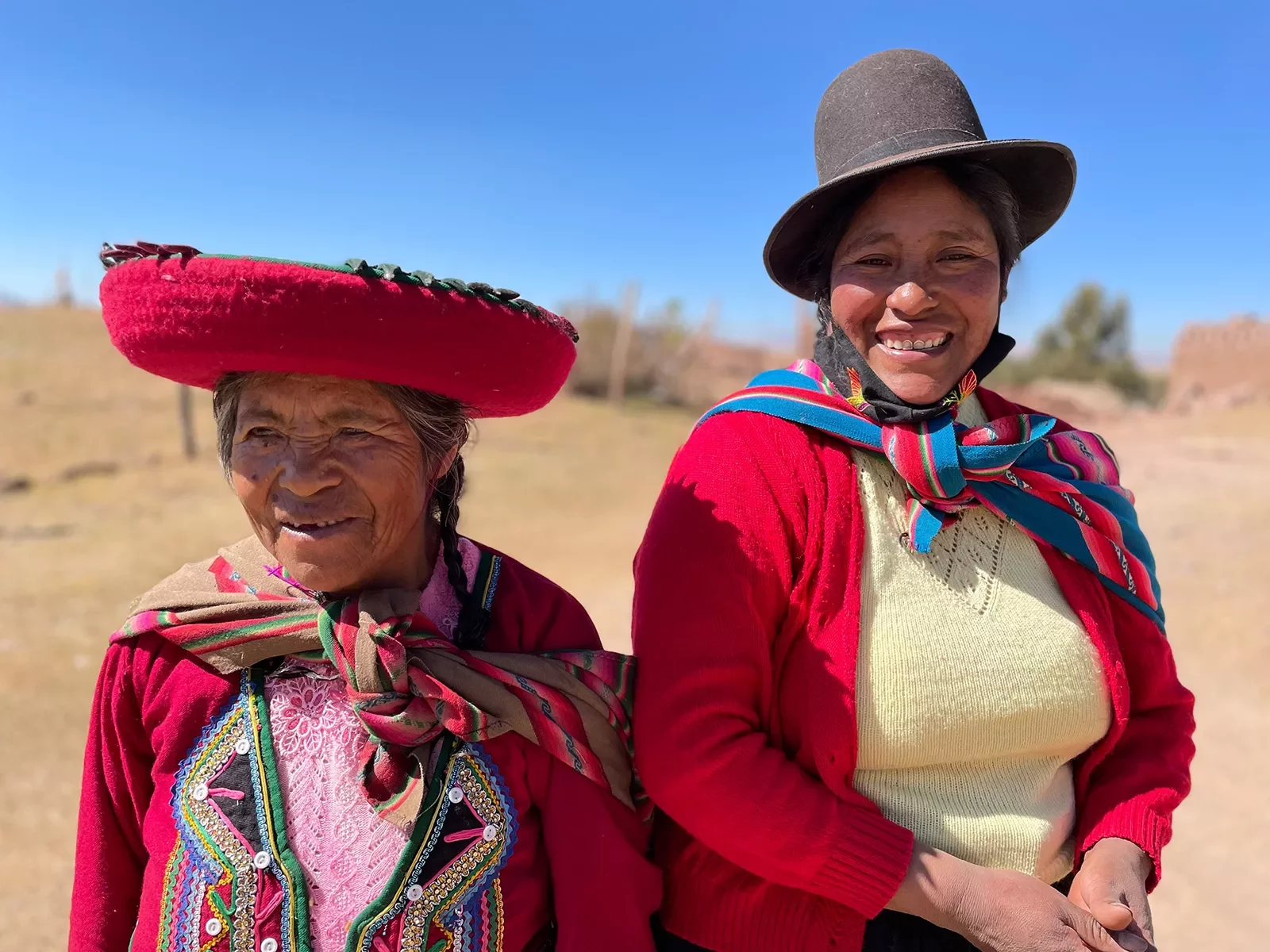 Two locals in colorful garb, both looking at camera, smiling.