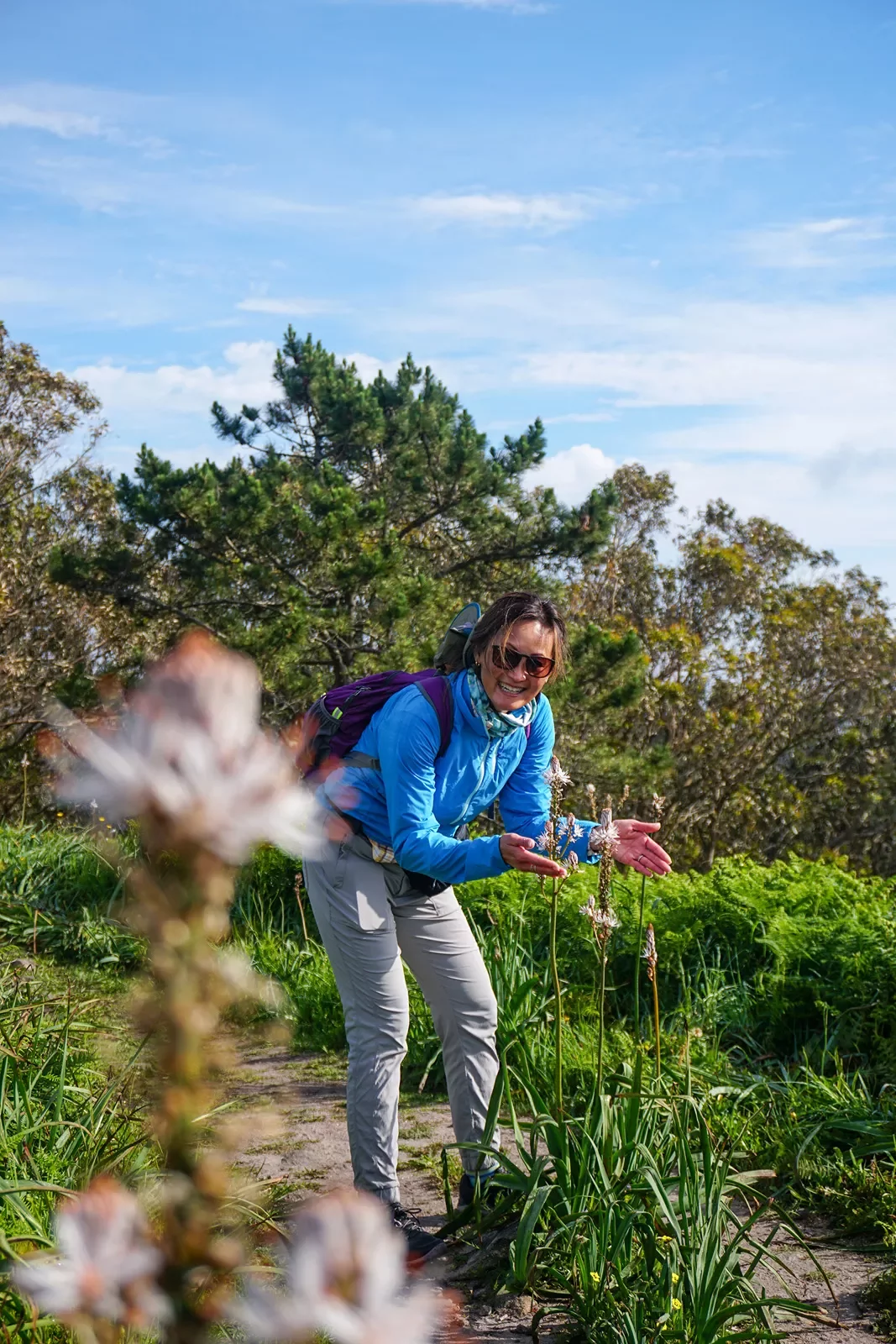 A hiker appreciating flowers