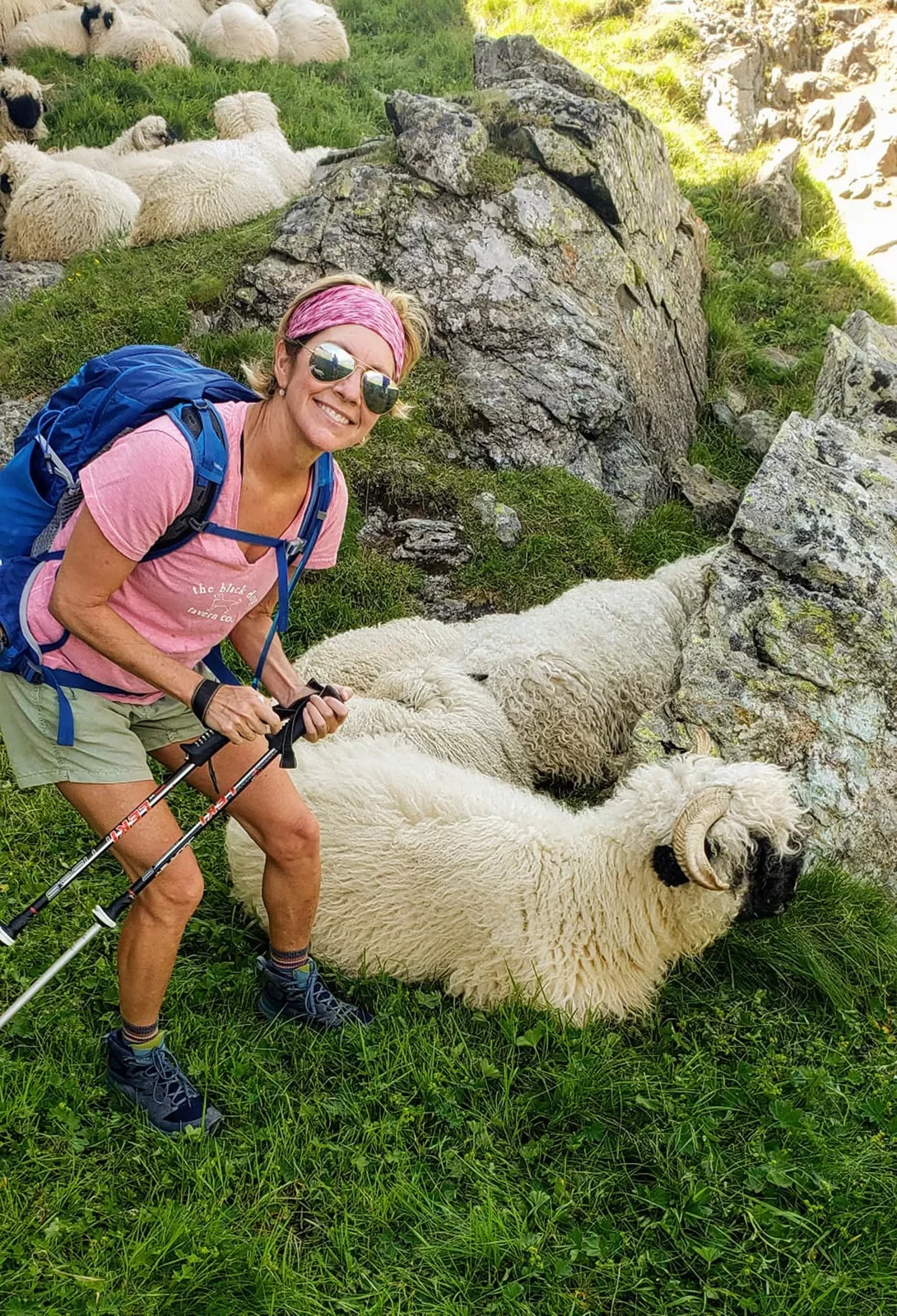 Hiker posing with two long haired sheep.