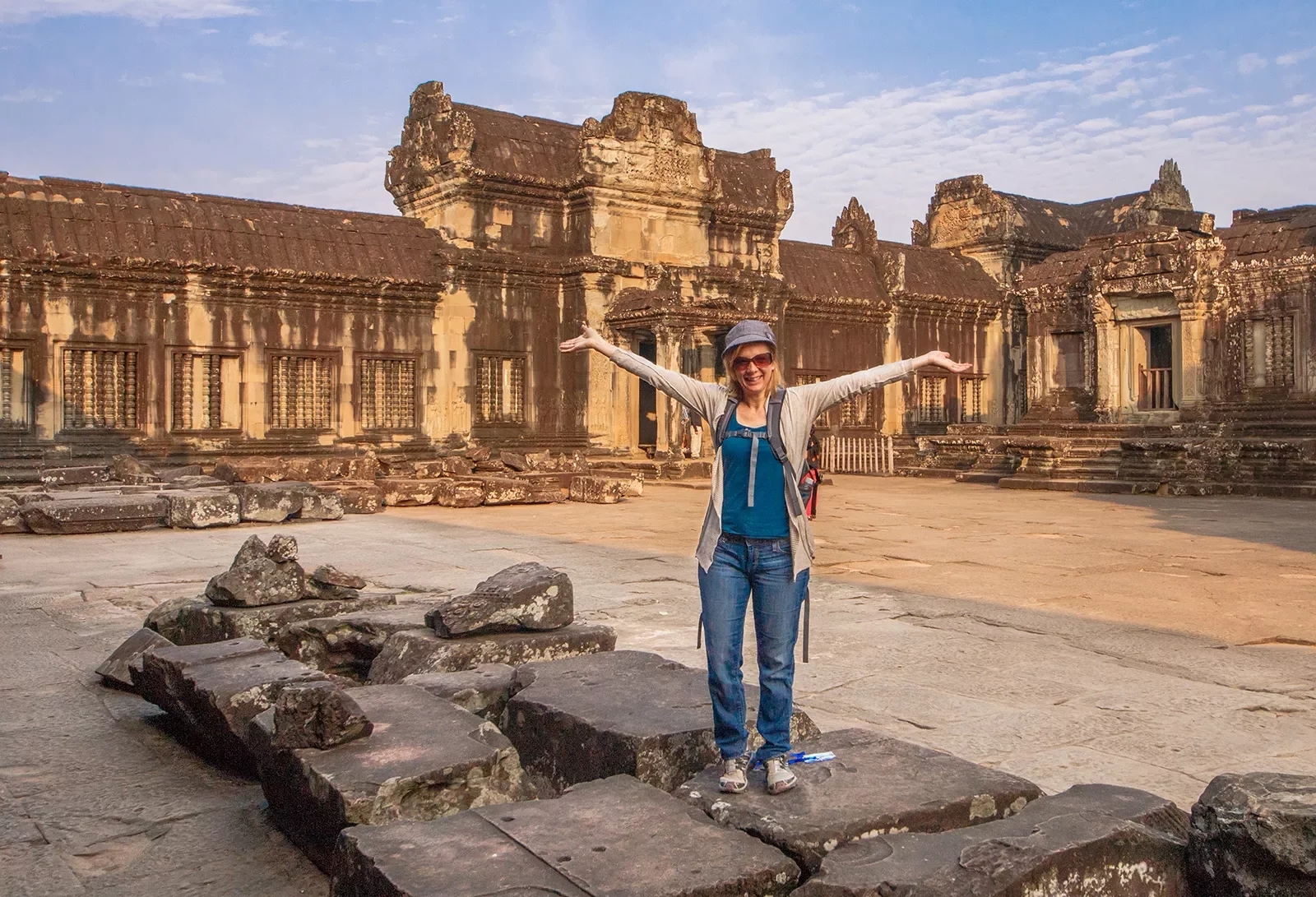 Person posing with arms outstretched in Angkor Wat