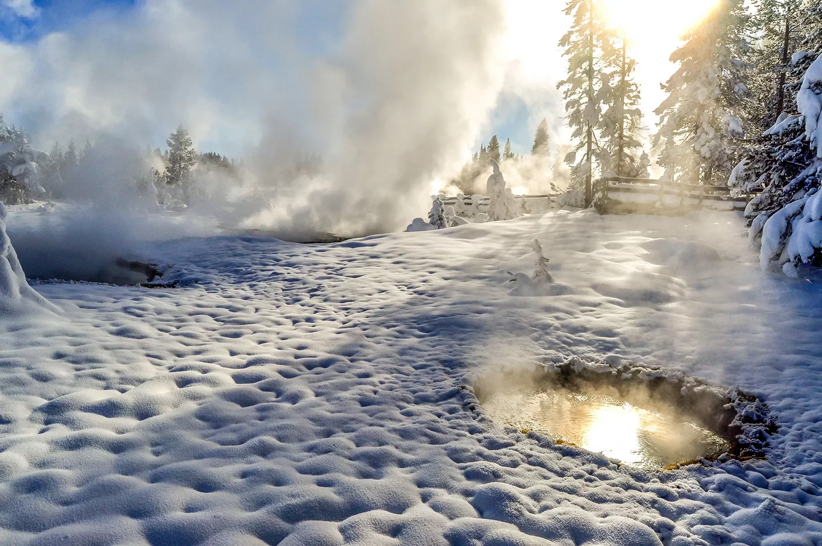 Snow covered landscape and hot springs with steam