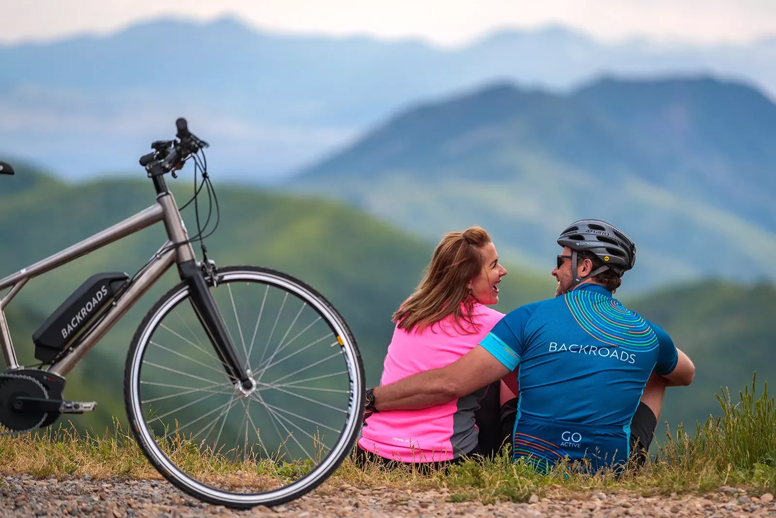 Cyclists sitting on a hill together in front of a Backroads ebike.