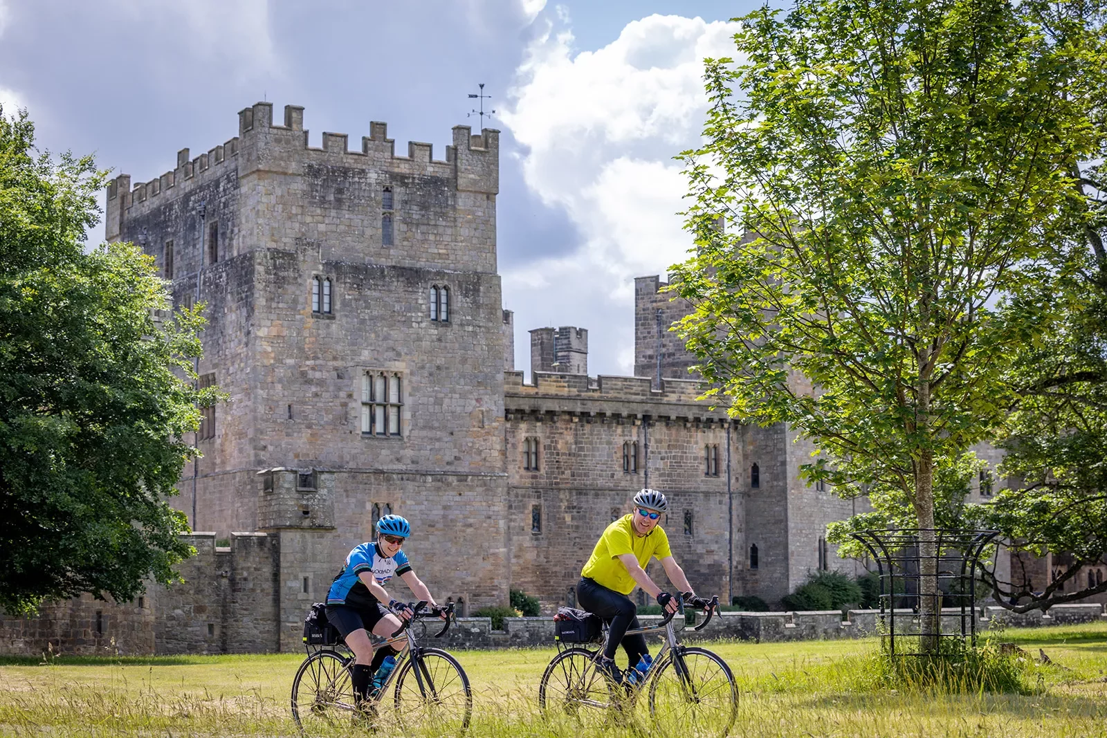 cyclists ride by a castle