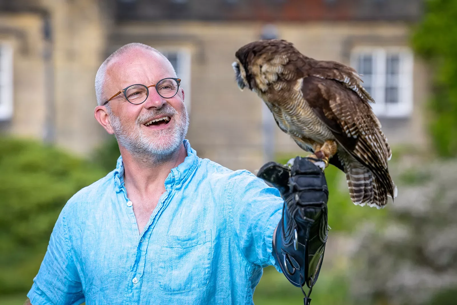 a man holding an owl