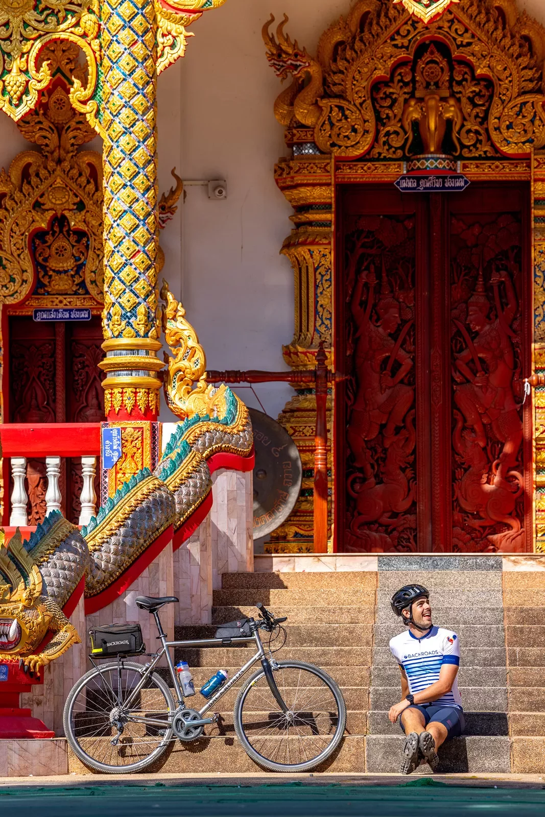Man and bike leaning against a red temple