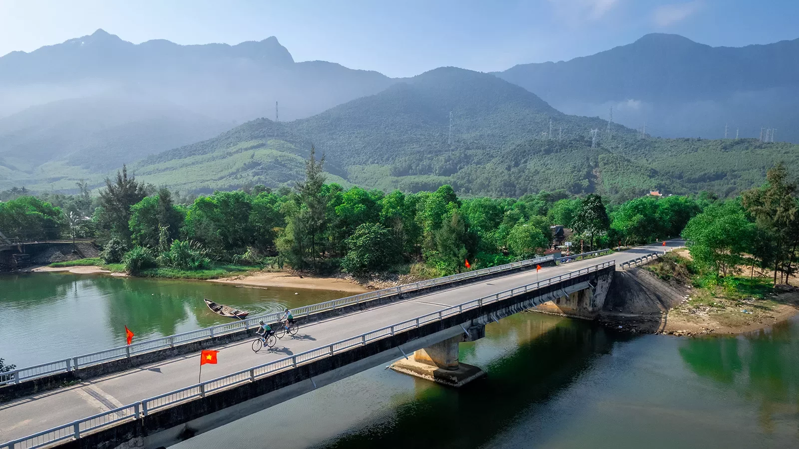 Bike riders cross a large bridge