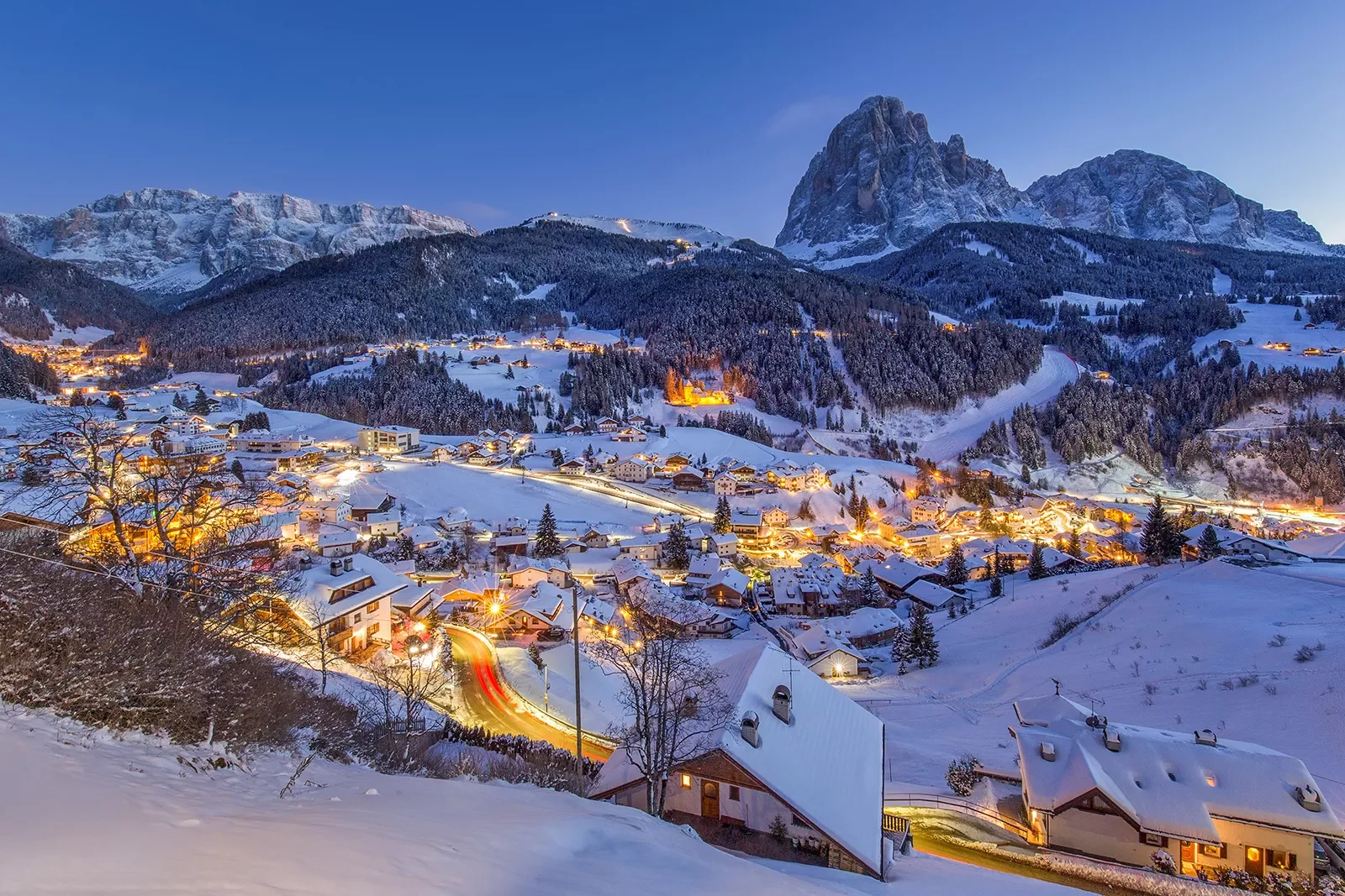 A small town covered in snow and lit up with lights