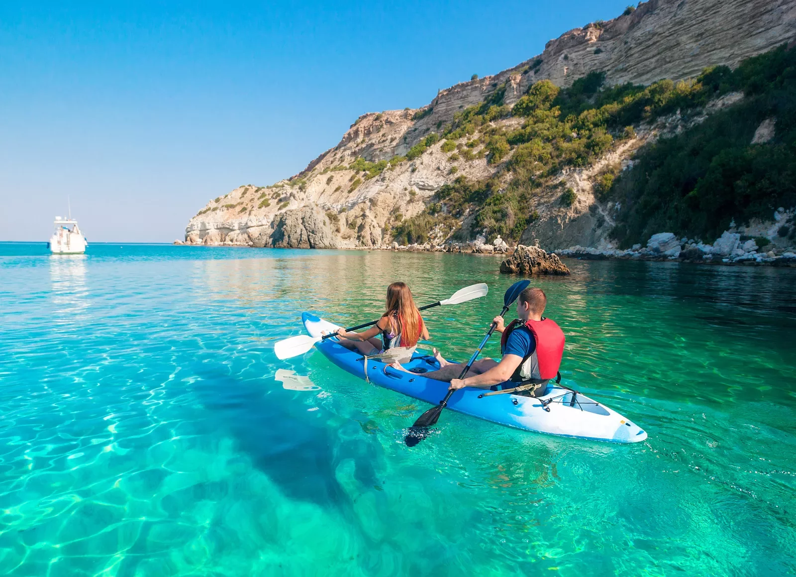 Two people kayaking in clear blue water