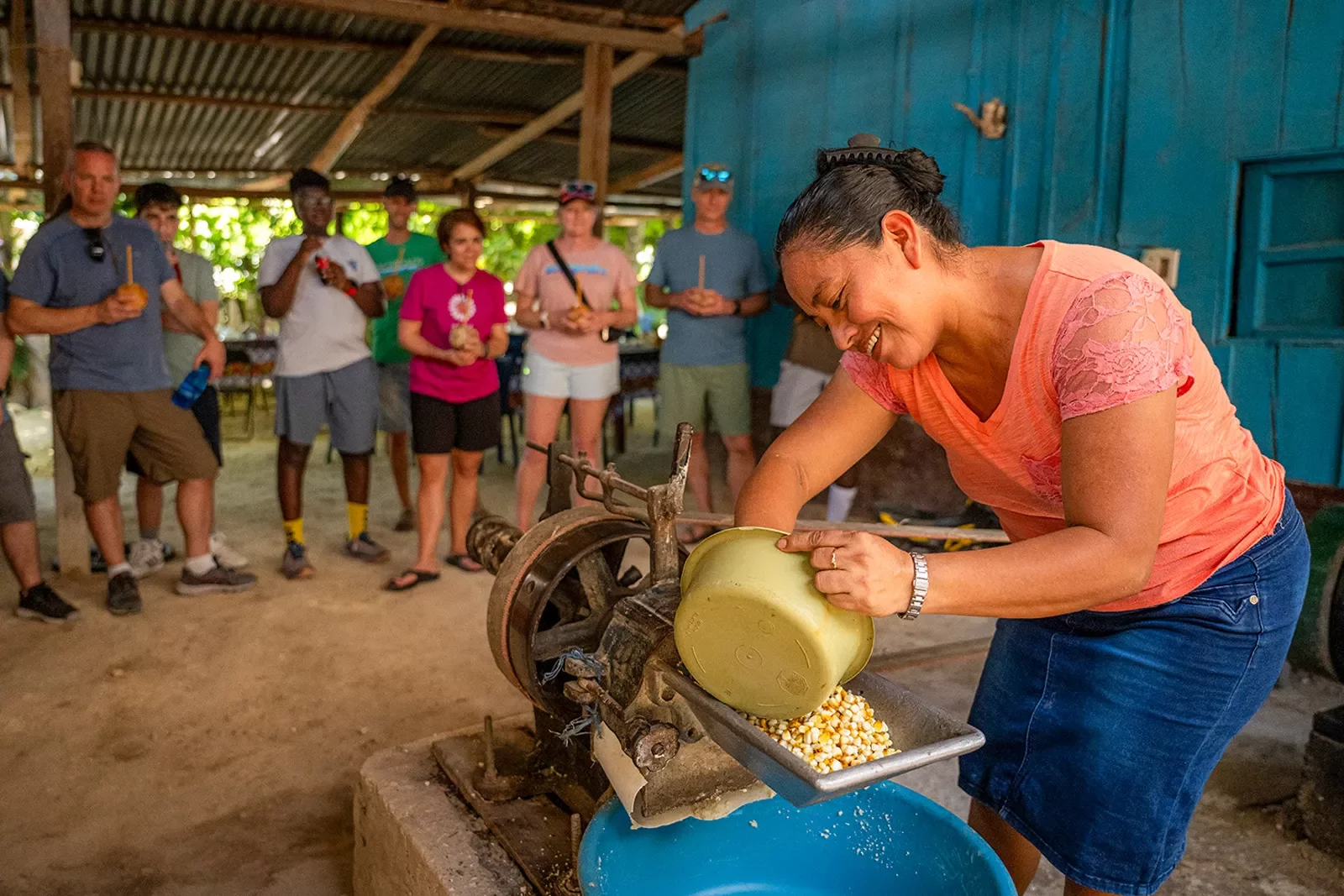Woman milling corn in a machine