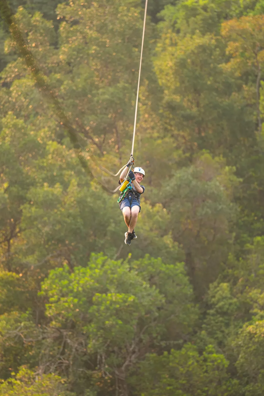 Woman ziplining in the middle of a forest