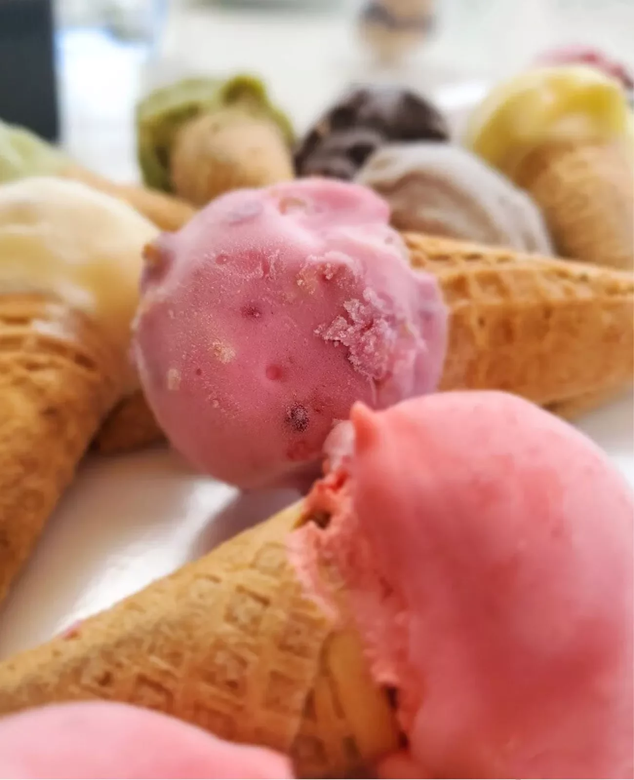 two ice cream cones topped with pink ice cream