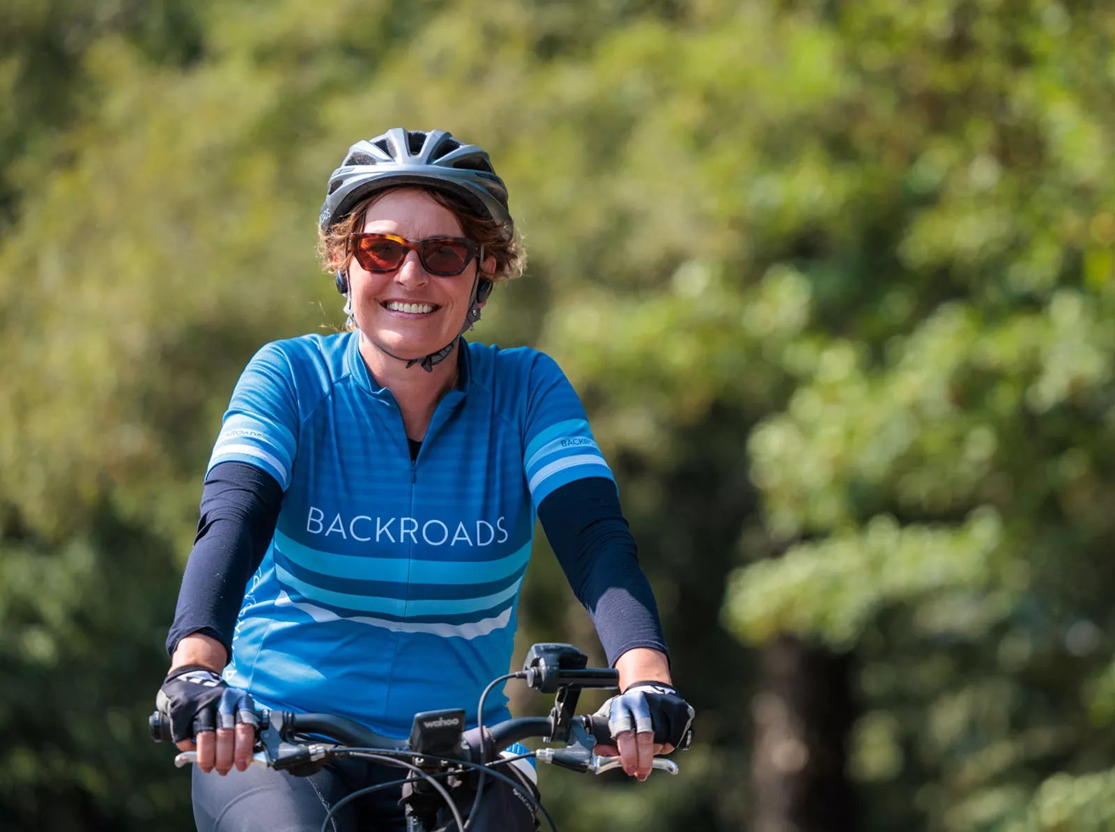 Woman smiling while riding a bike on a road