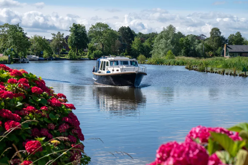 Boat on a lake with large trees surrounding the lake