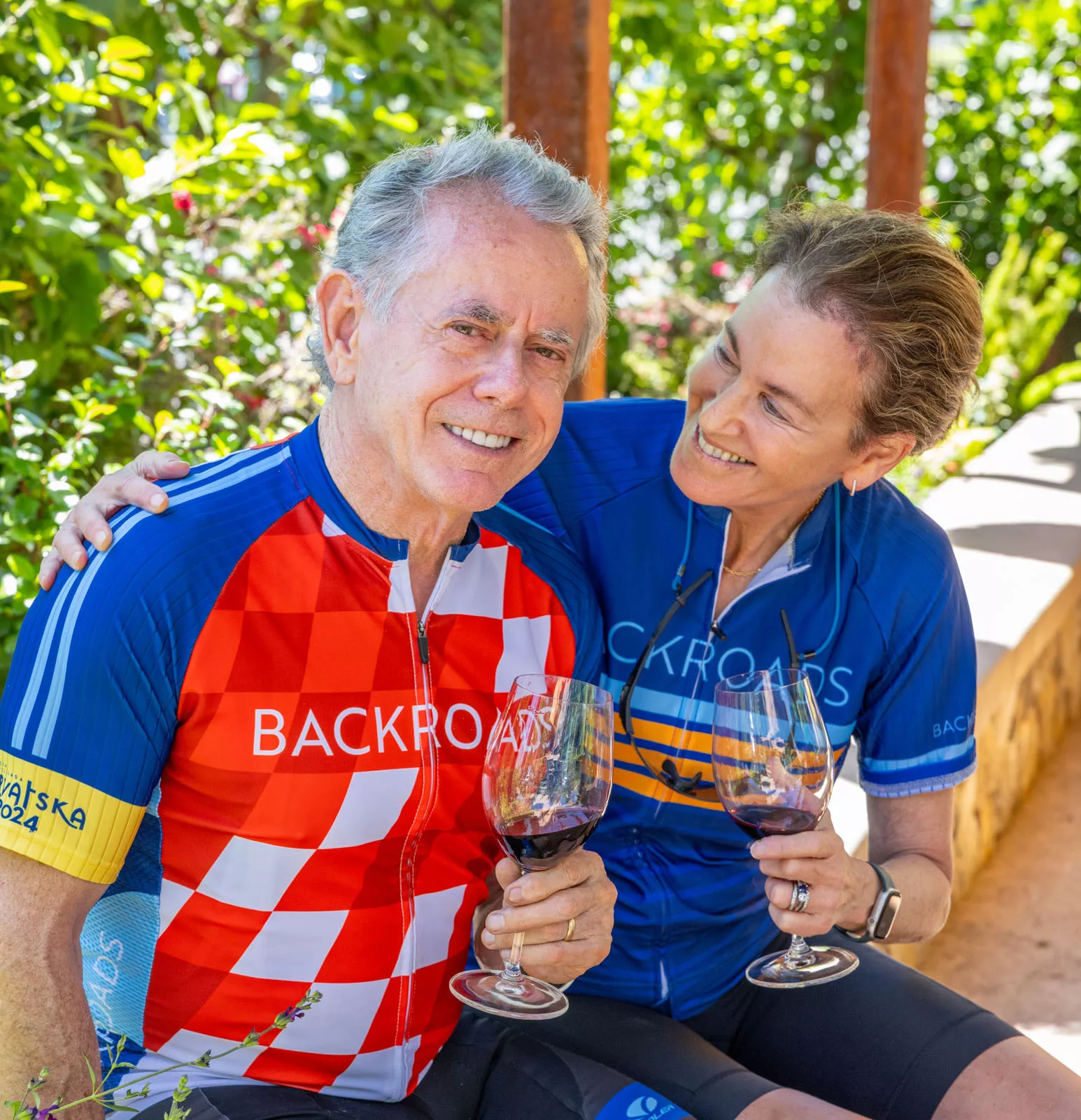 Man and woman holding wine glasses, smiling while looking at each other