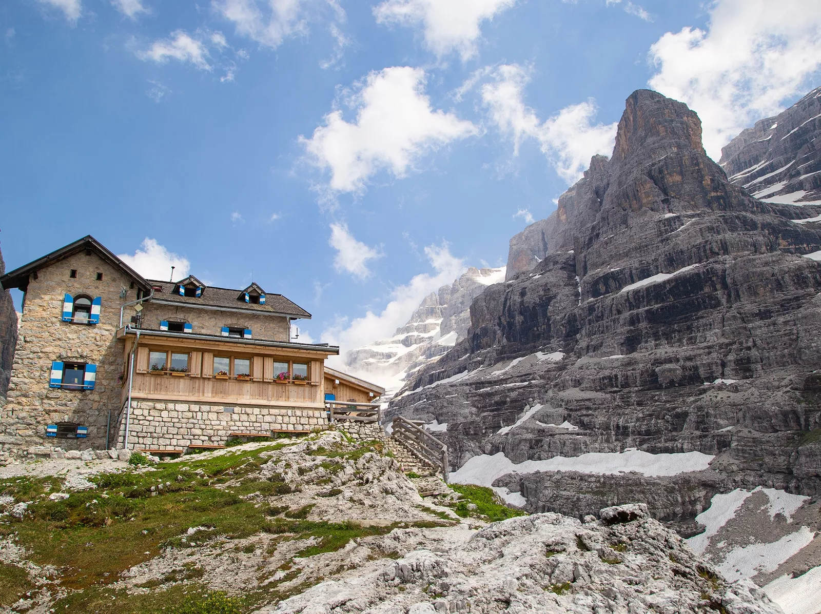 Large, stone building on top of a hill, with a large, snow-capped mountain to the right