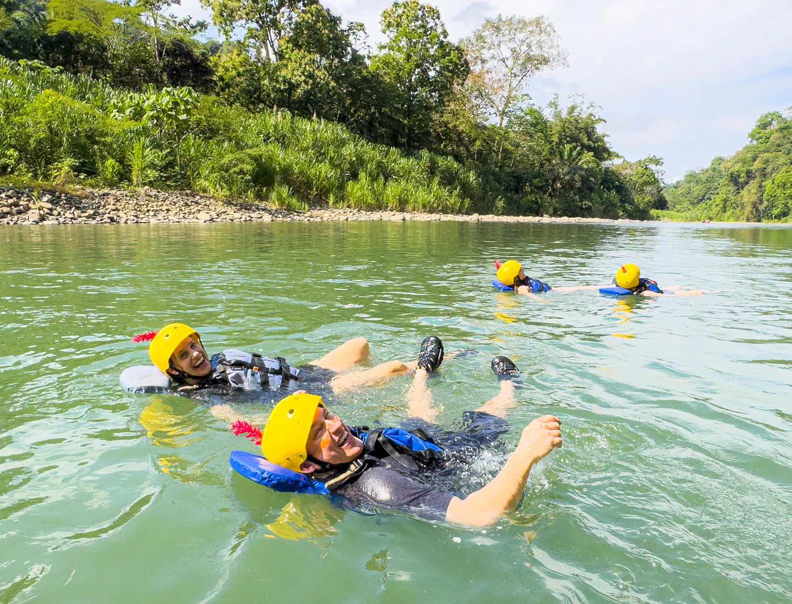 Man and woman smiling while floating in a river