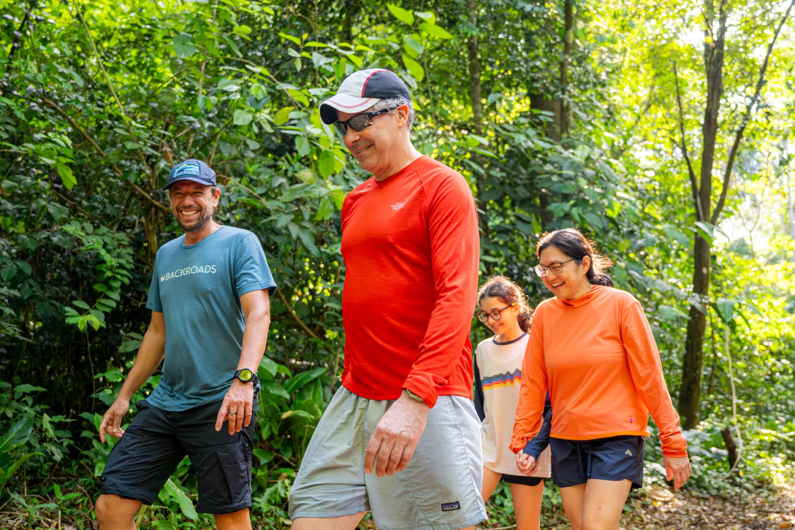 Two men and two women walking as a group in a forest