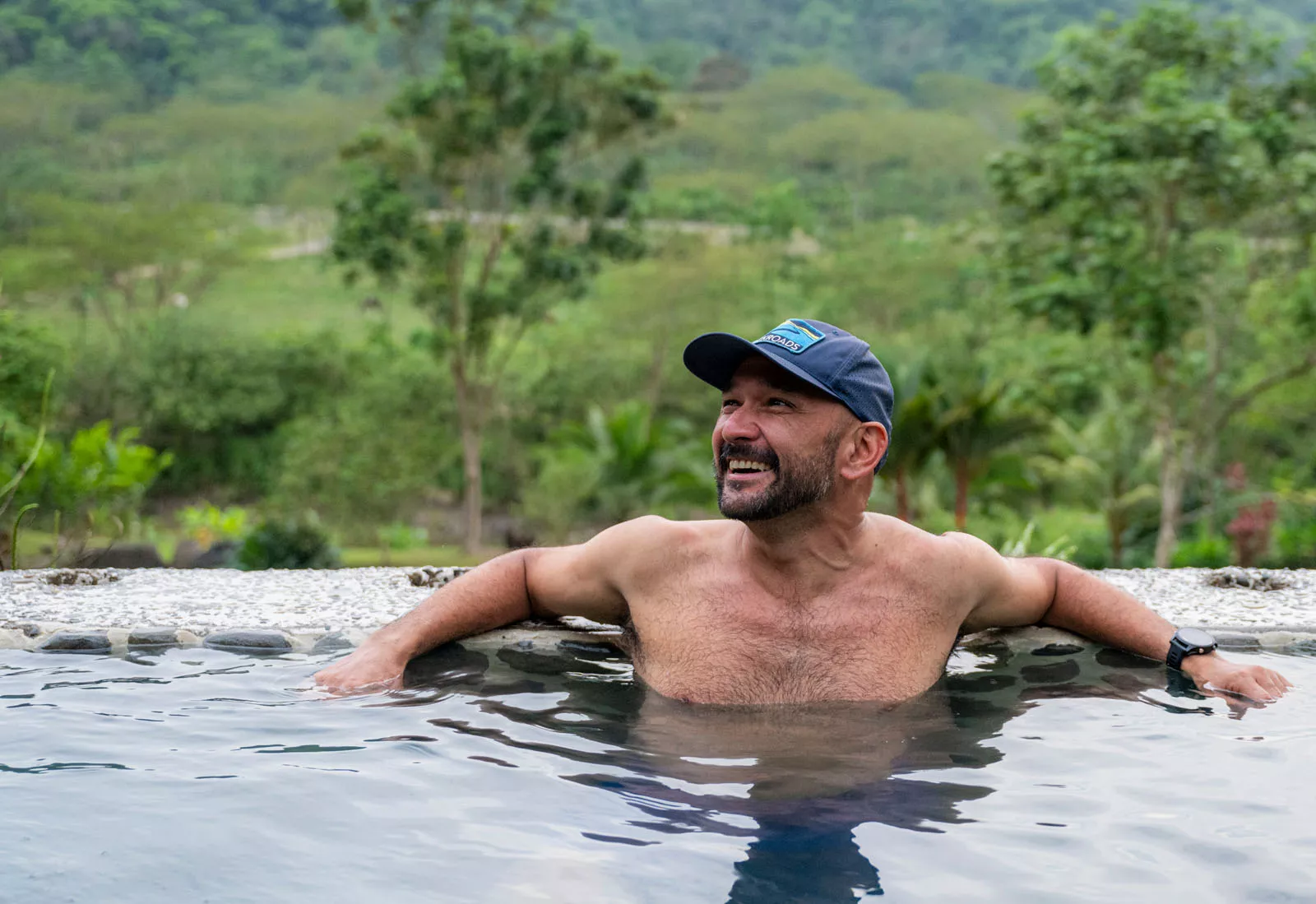 Man smiling while sitting in a hot spring