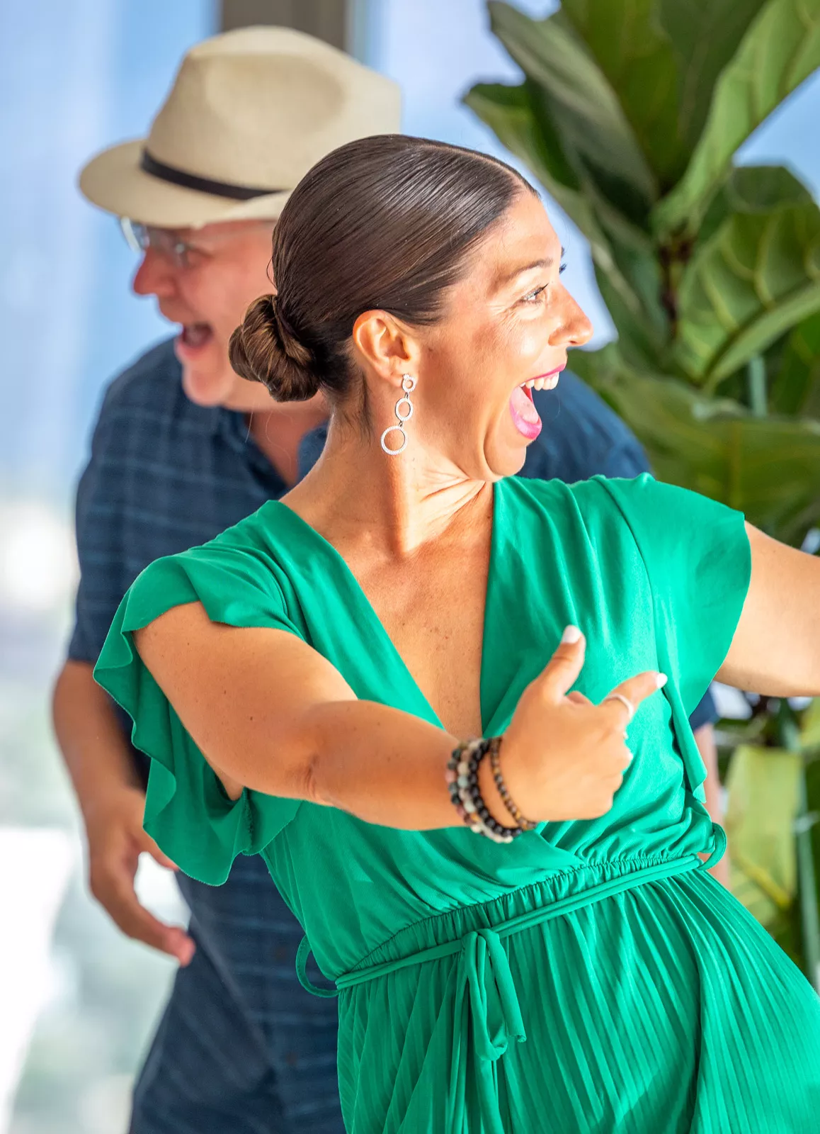 Woman in a green dress, laughing and smiling while dancing