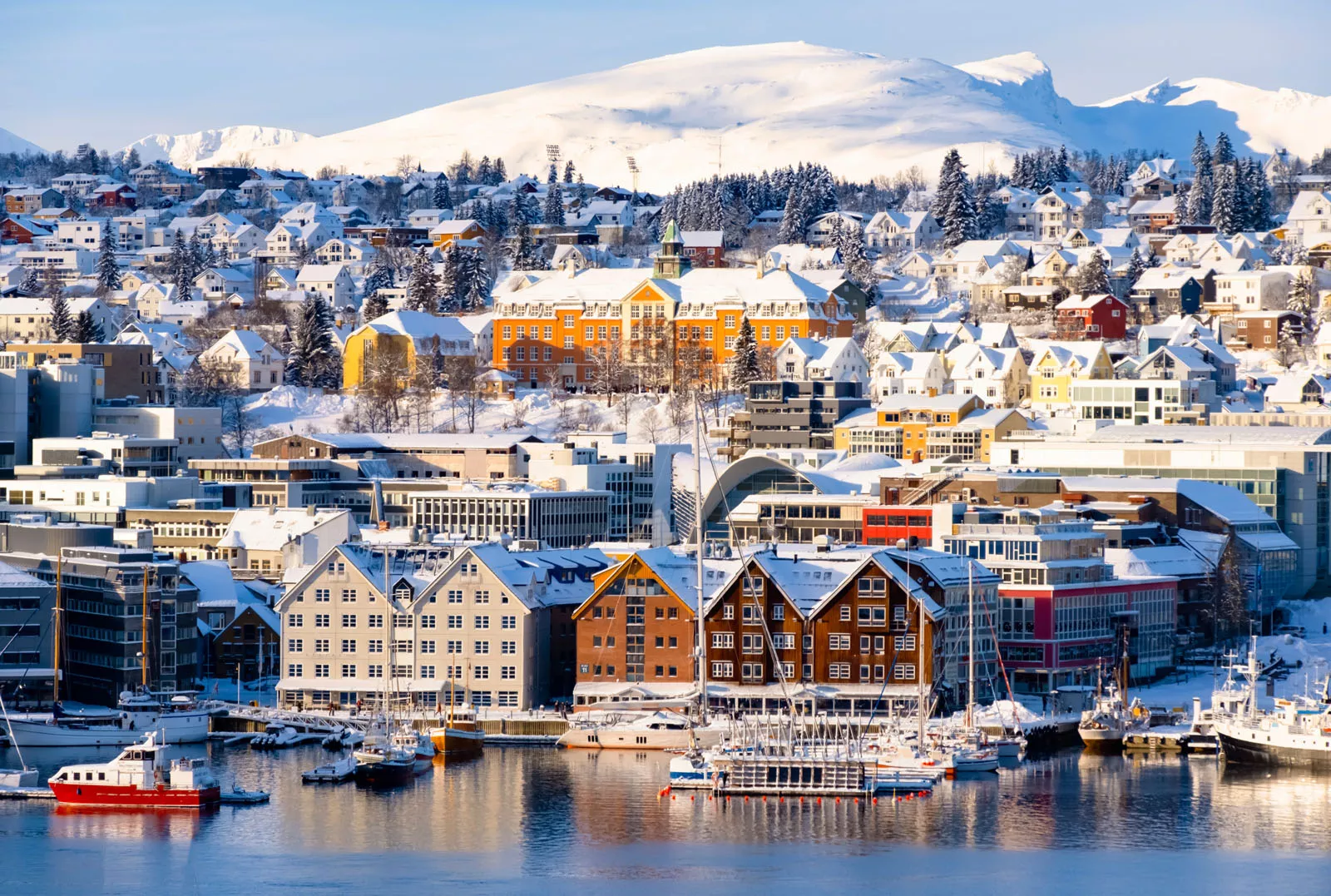 Wide view of a town, covered with snow and a lake in front