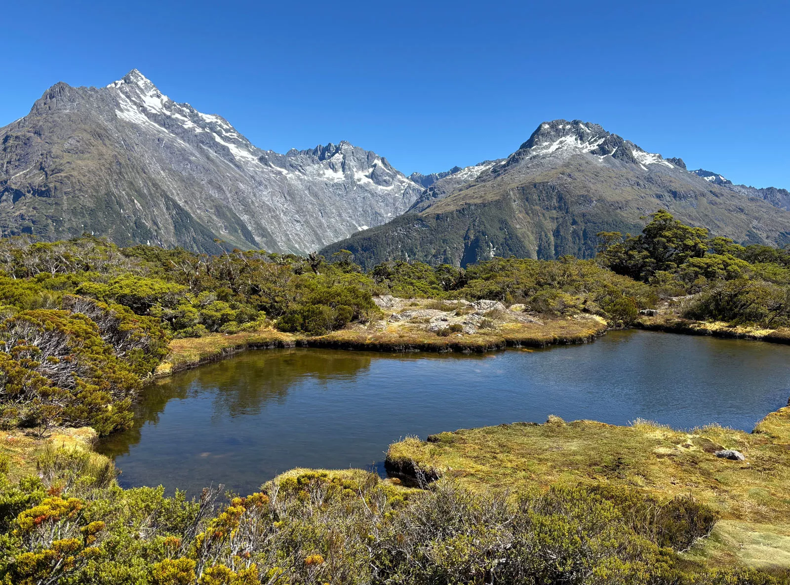 Small lake surrounded by large mountains and hills