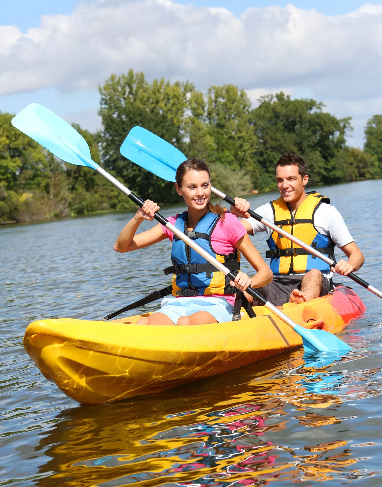 Man and woman paddling in a yellow kayak
