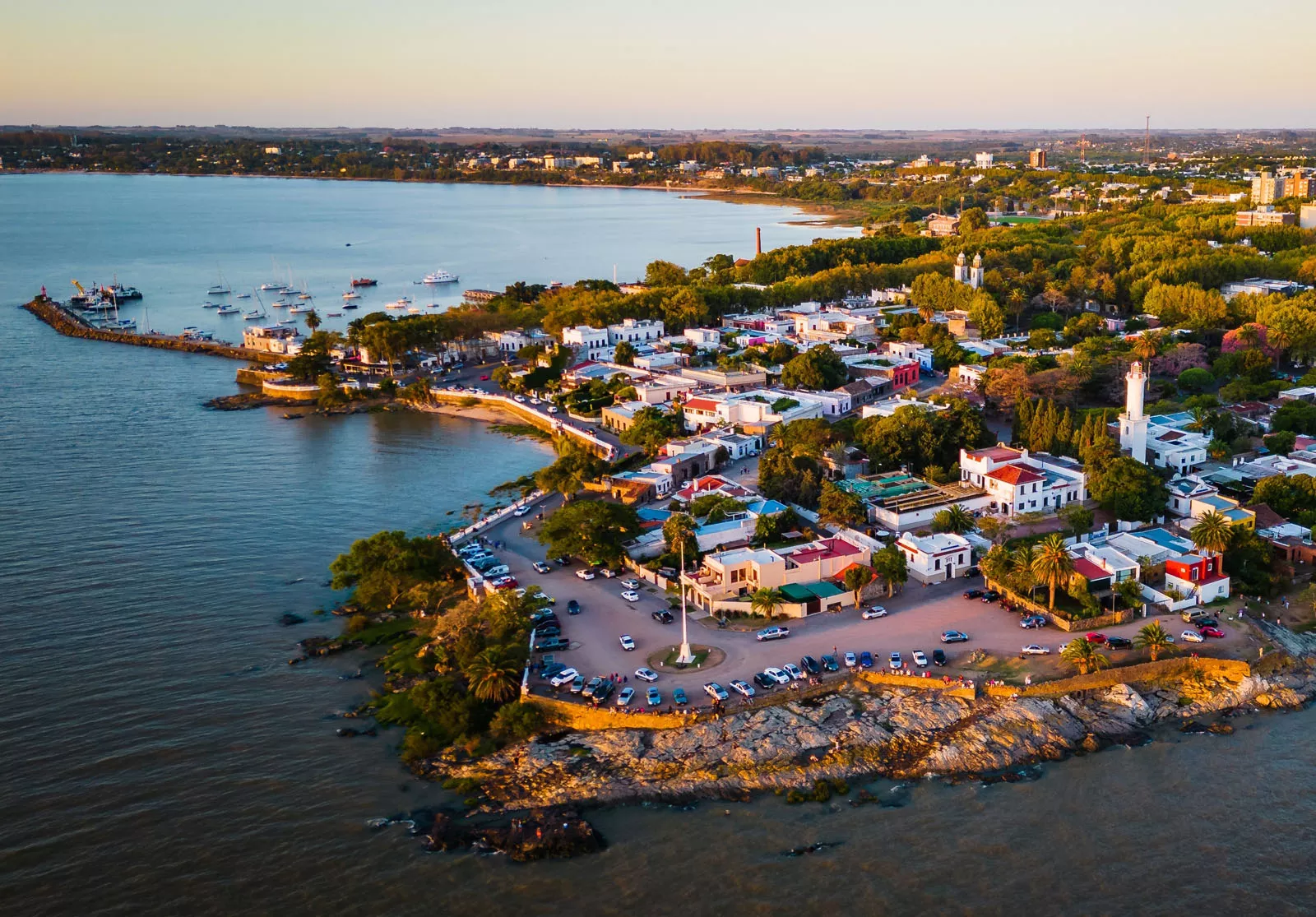 Sky view of small town by the ocean, with cars parked along the beach