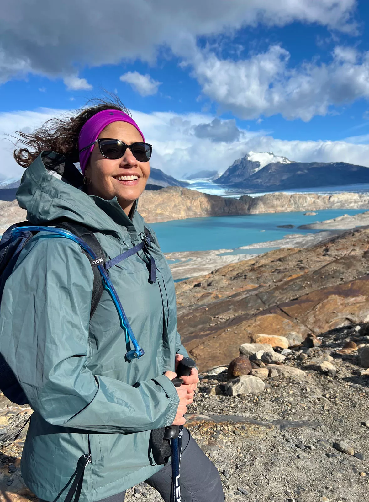 Woman smiling while ascending a rocky hill