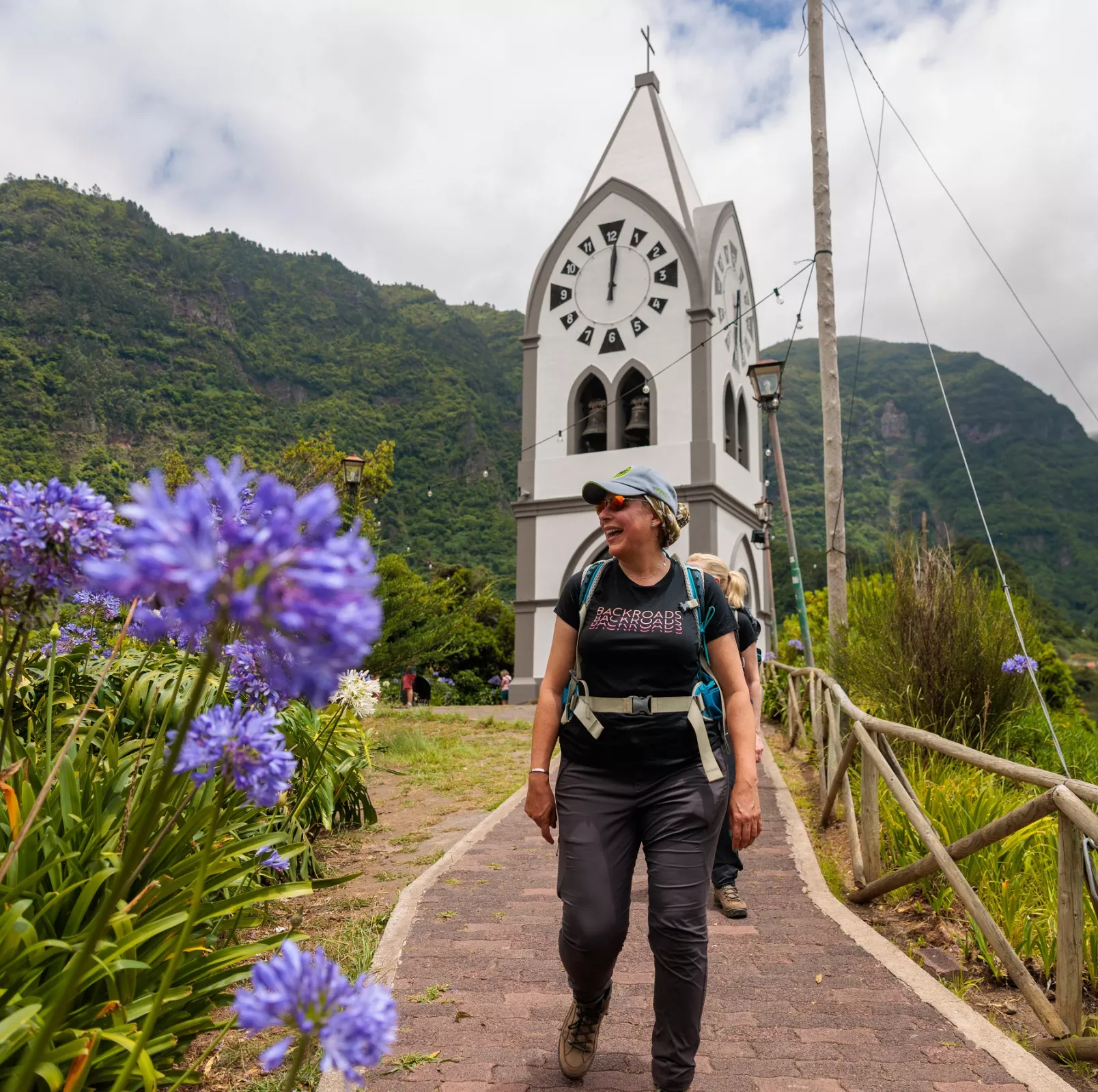 Woman smiling, with a large church clocktower in the background