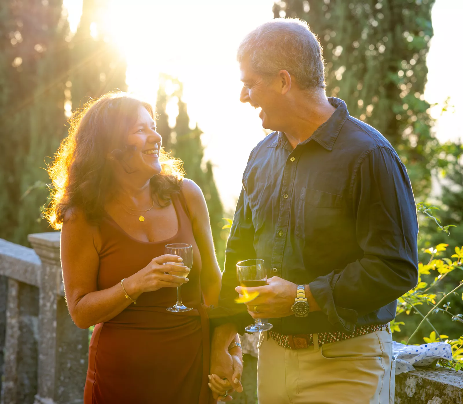 Man and woman smiling at each other, while holding glasses of wine