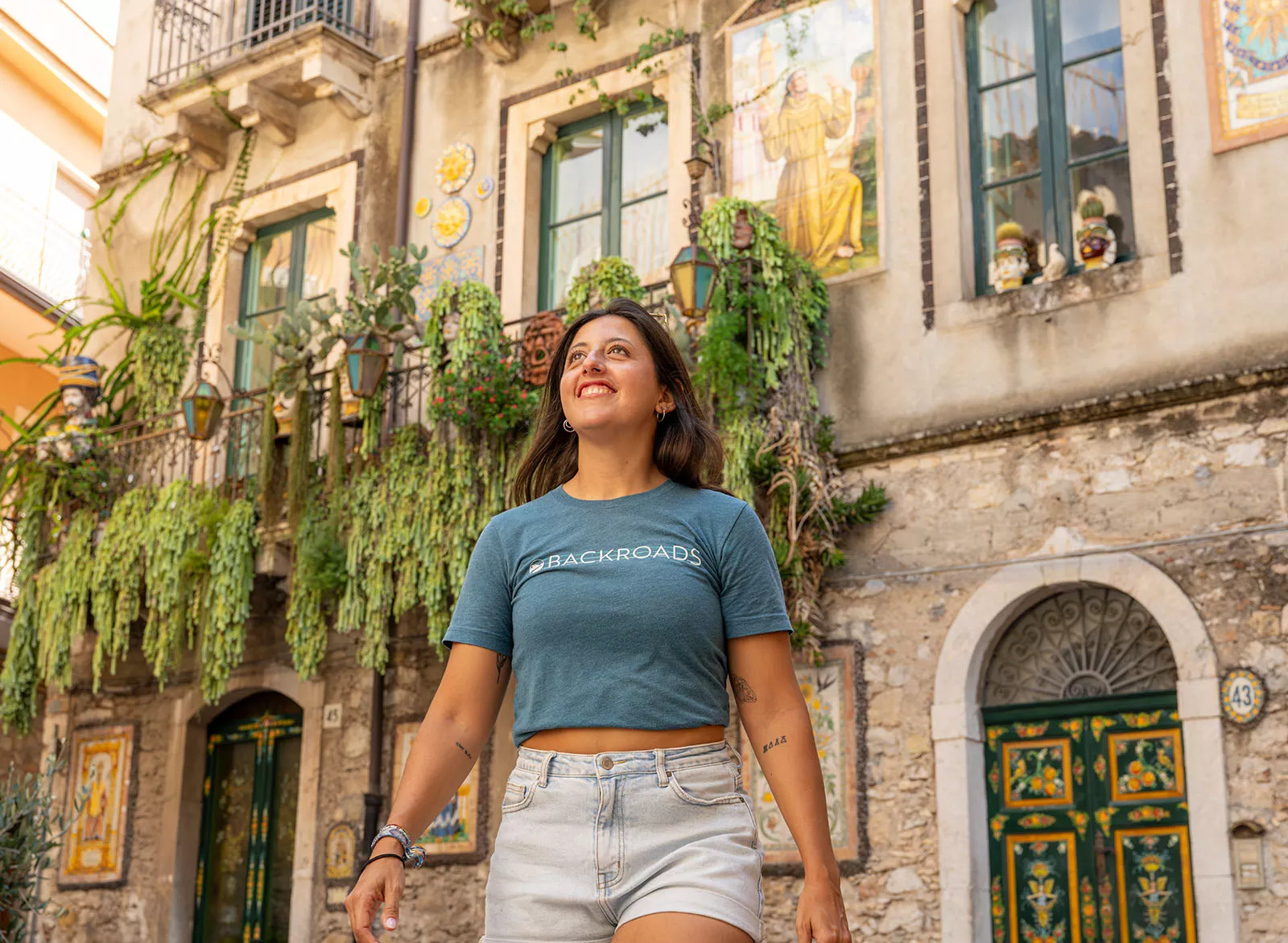 Woman smiling while looking up, with a stone building in the background