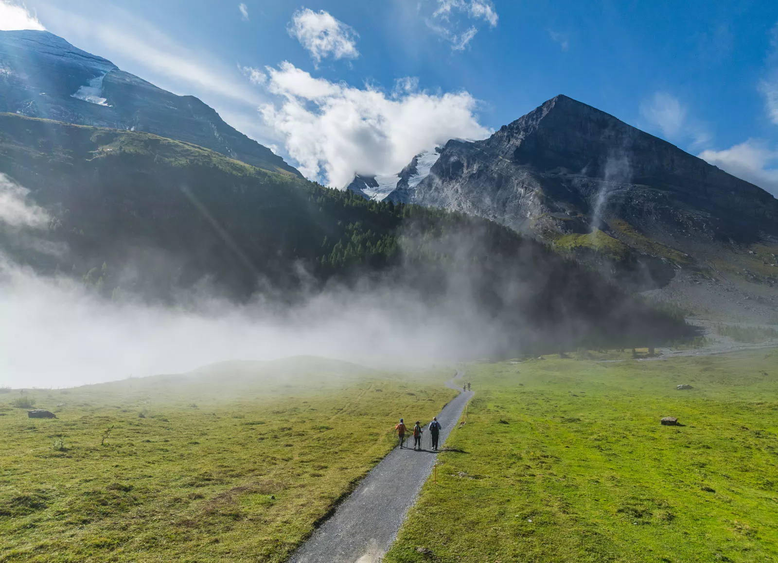 backroads guests walk down a path towards a mountain