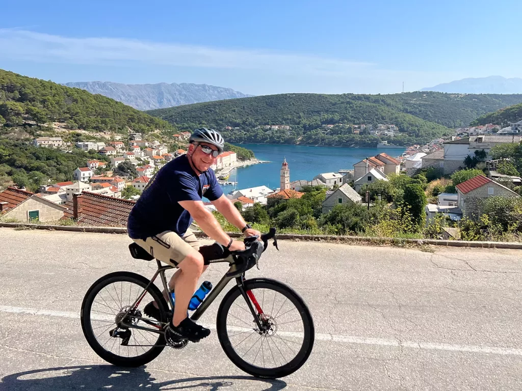Guest cycling past Croatian riverside town.