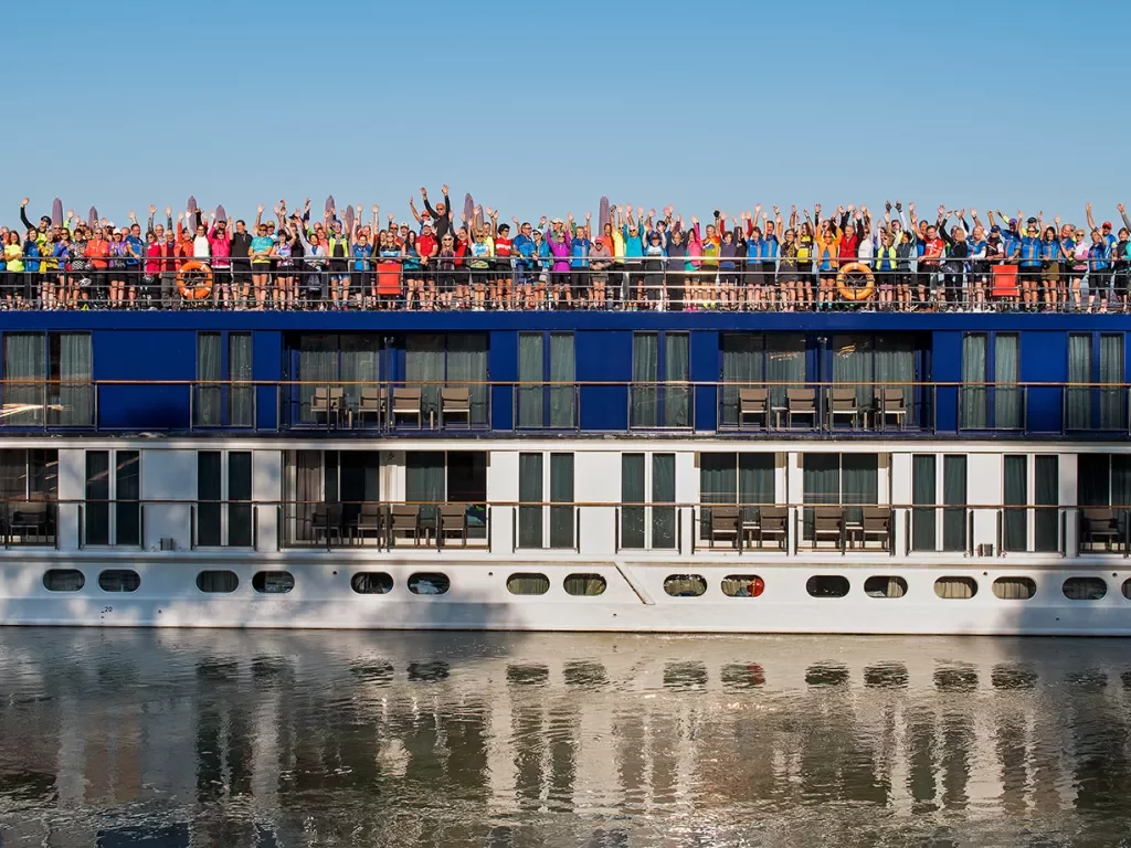 Cruise guests gathered on top deck, celebrating.
