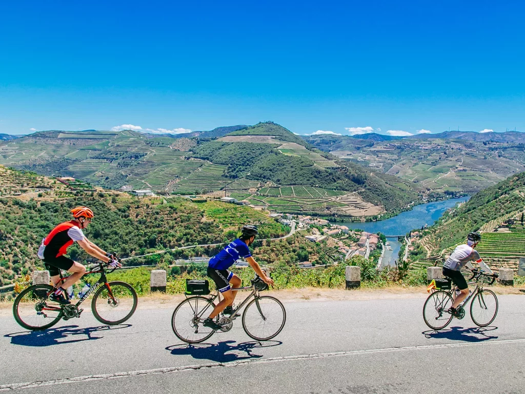Three bikers riding on a road along the Douro River.