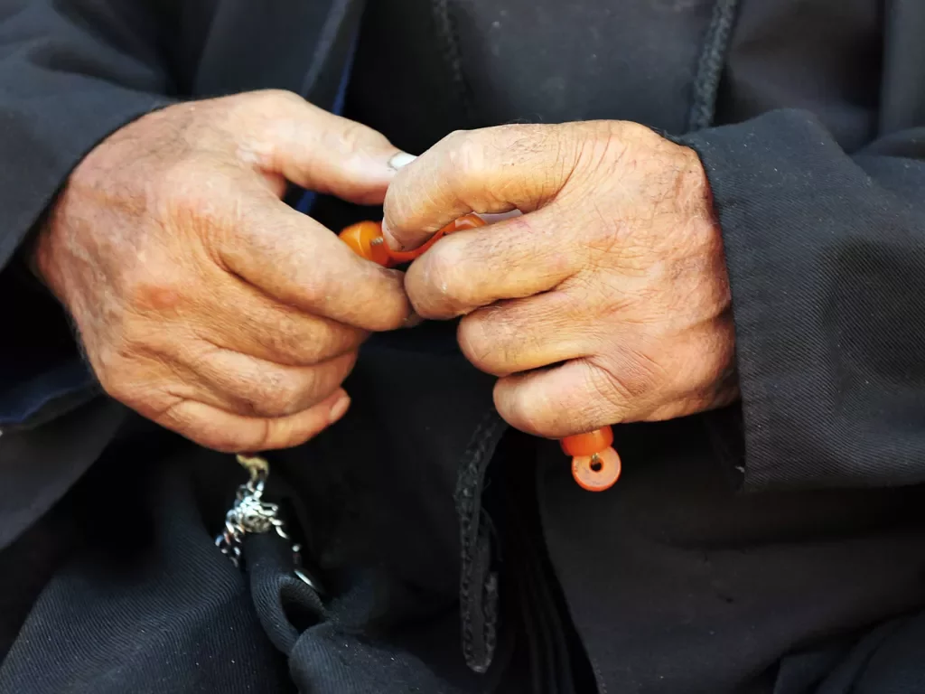 Hands holding prayer beads