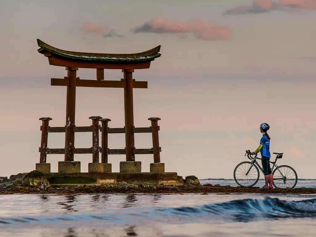 Backroads guest with bike next to Japanese structure 